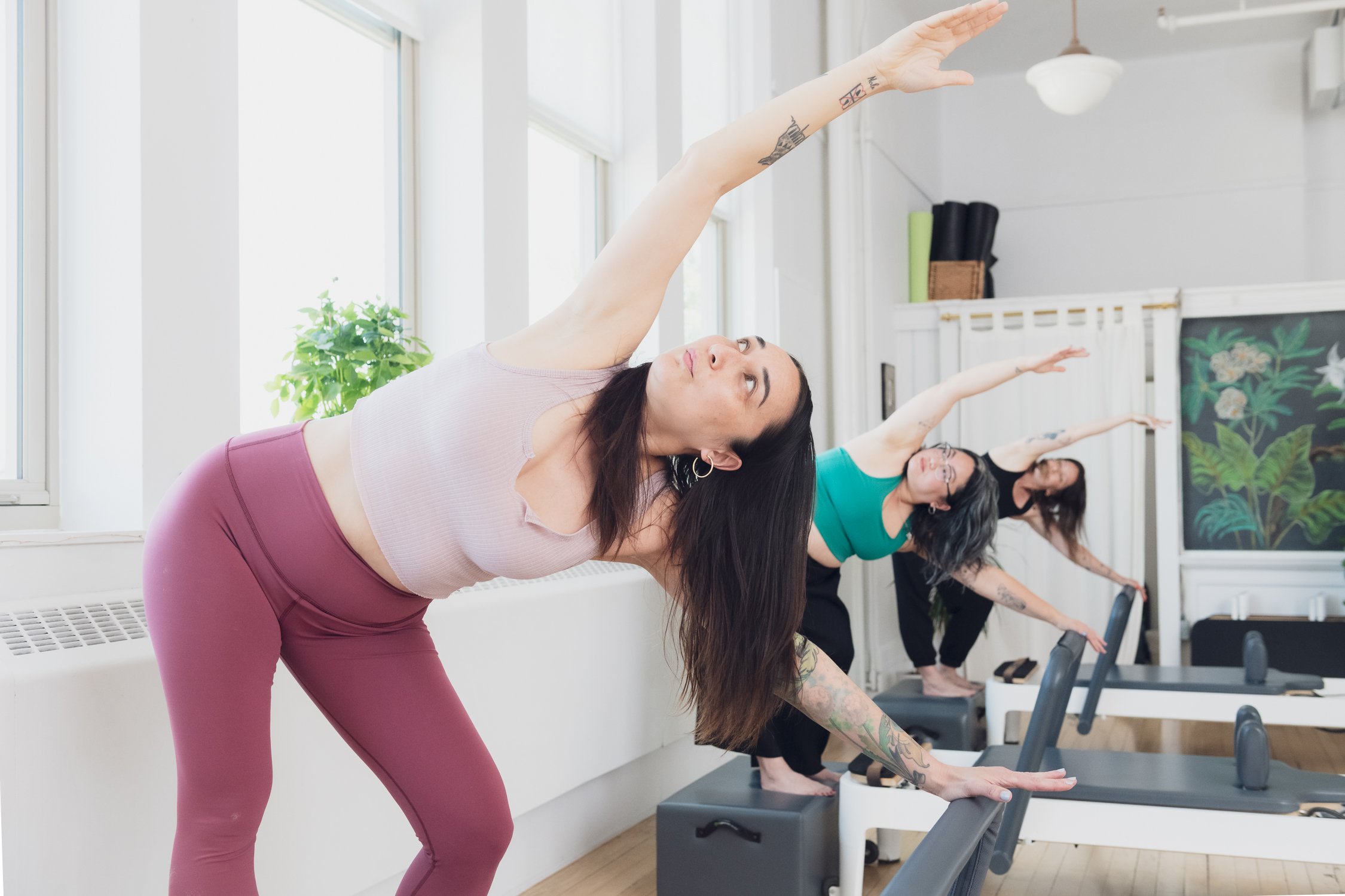 Students stretching during reformer teacher training at Muse Movement in Toronto