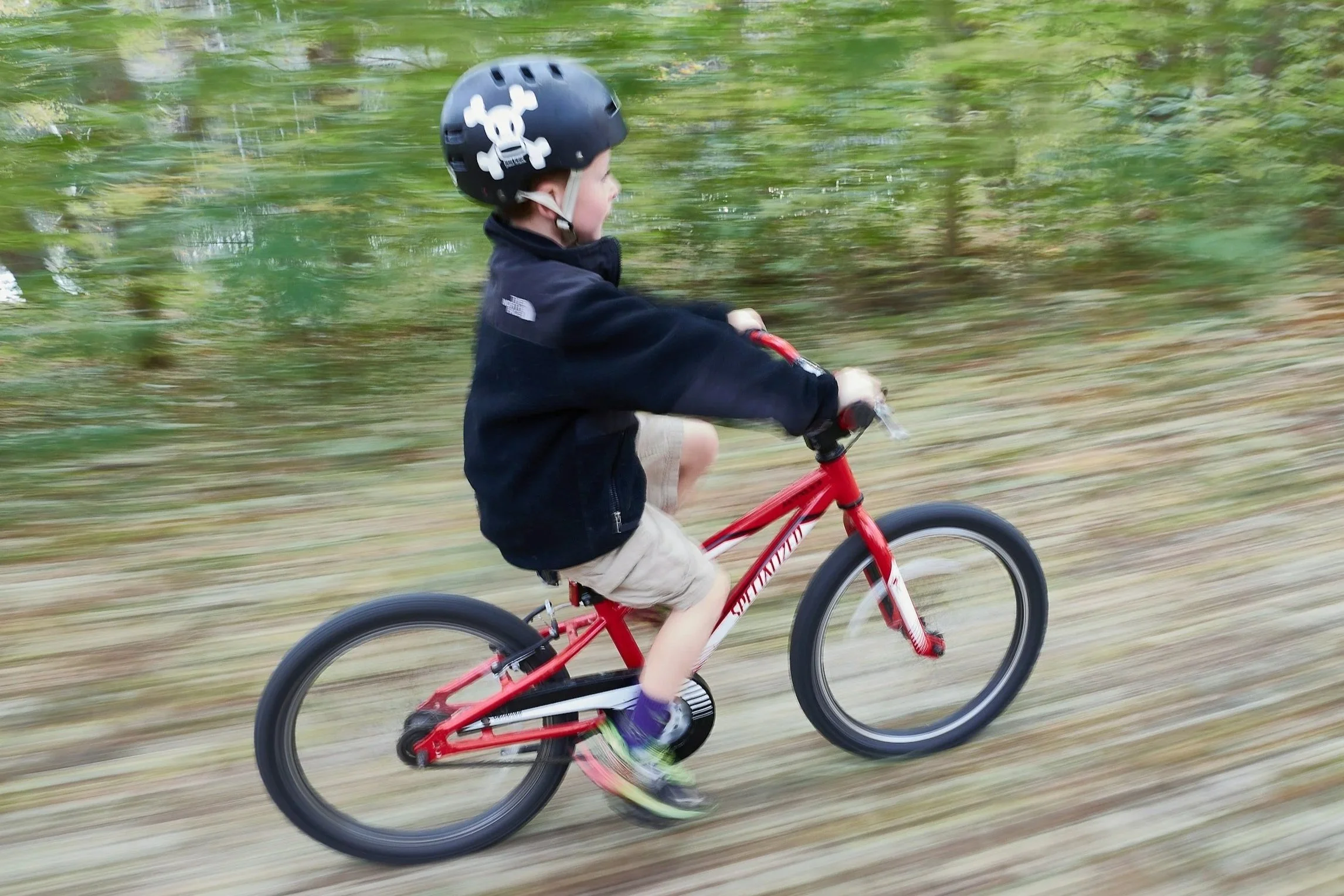 Child learning to ride a bike without training wheels
