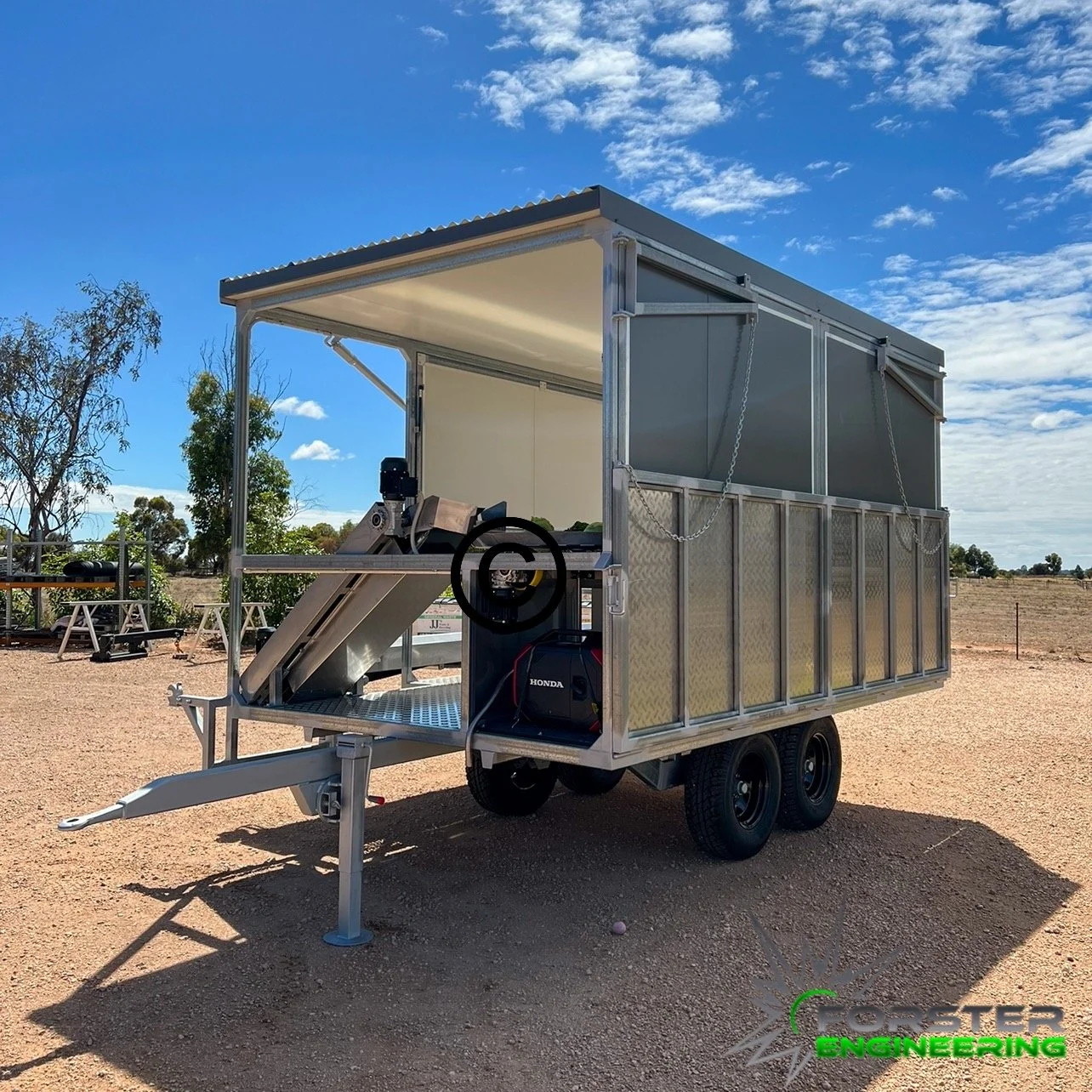 A Lettuce Harvesting Aid used by Farmers to Harvest their lettuce crops on sandy ground with blue sky and scattered clouds.