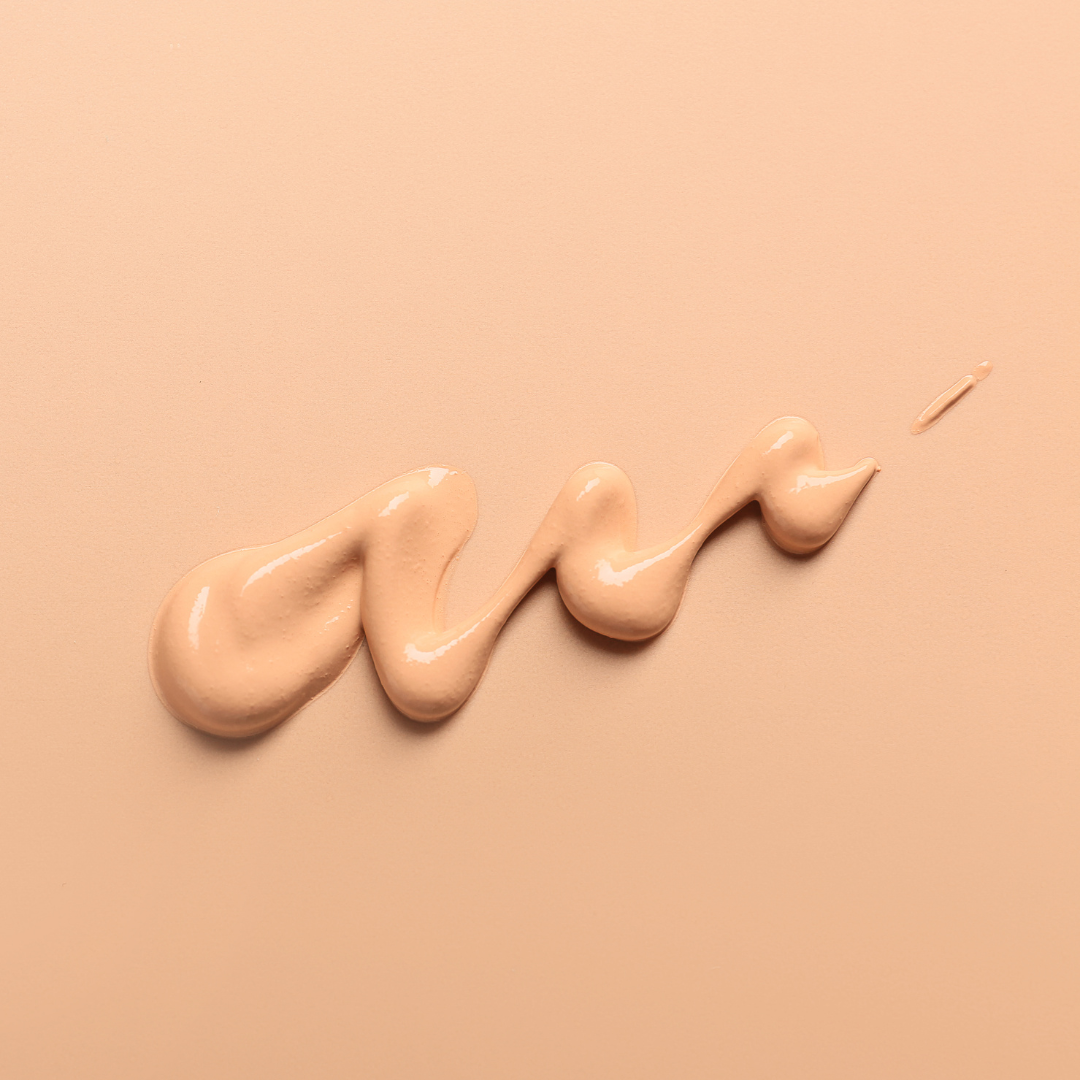 A close up of concealer in a pot in a woman's hand