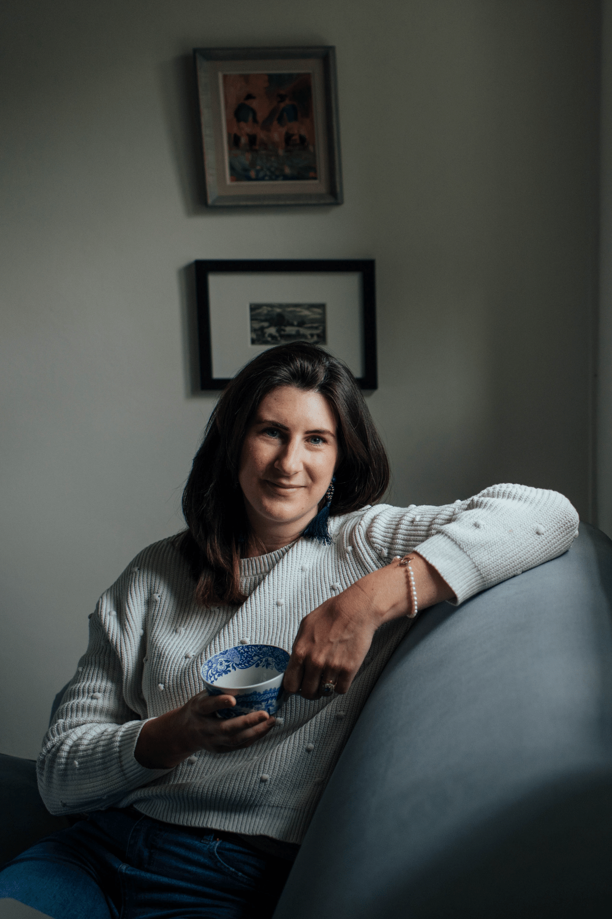 Josephine Brooks sat on a sofa drinking tea