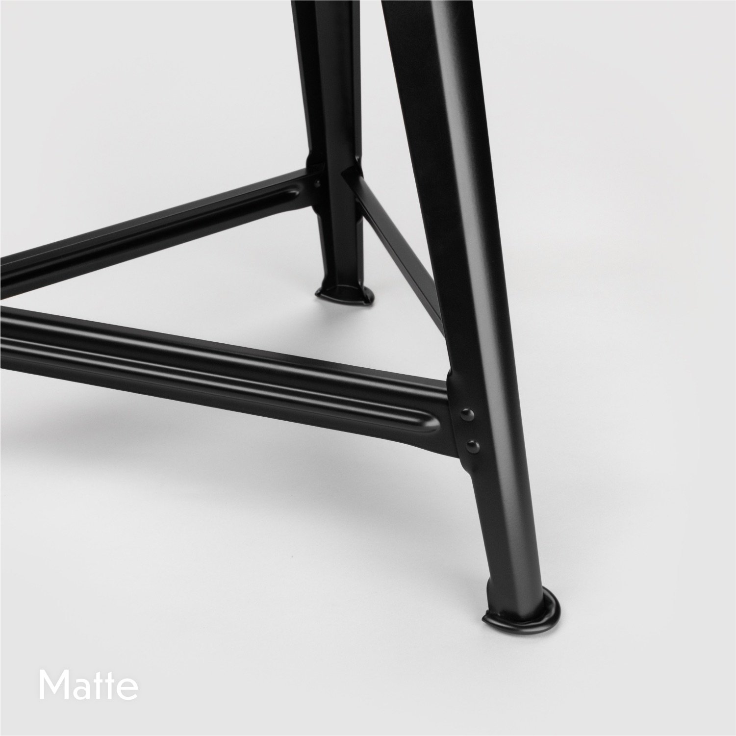 Rowac Model 1 industrial Schemel or workshop stool – detail view of riveted metal / steel foot design. Frame in matte black.