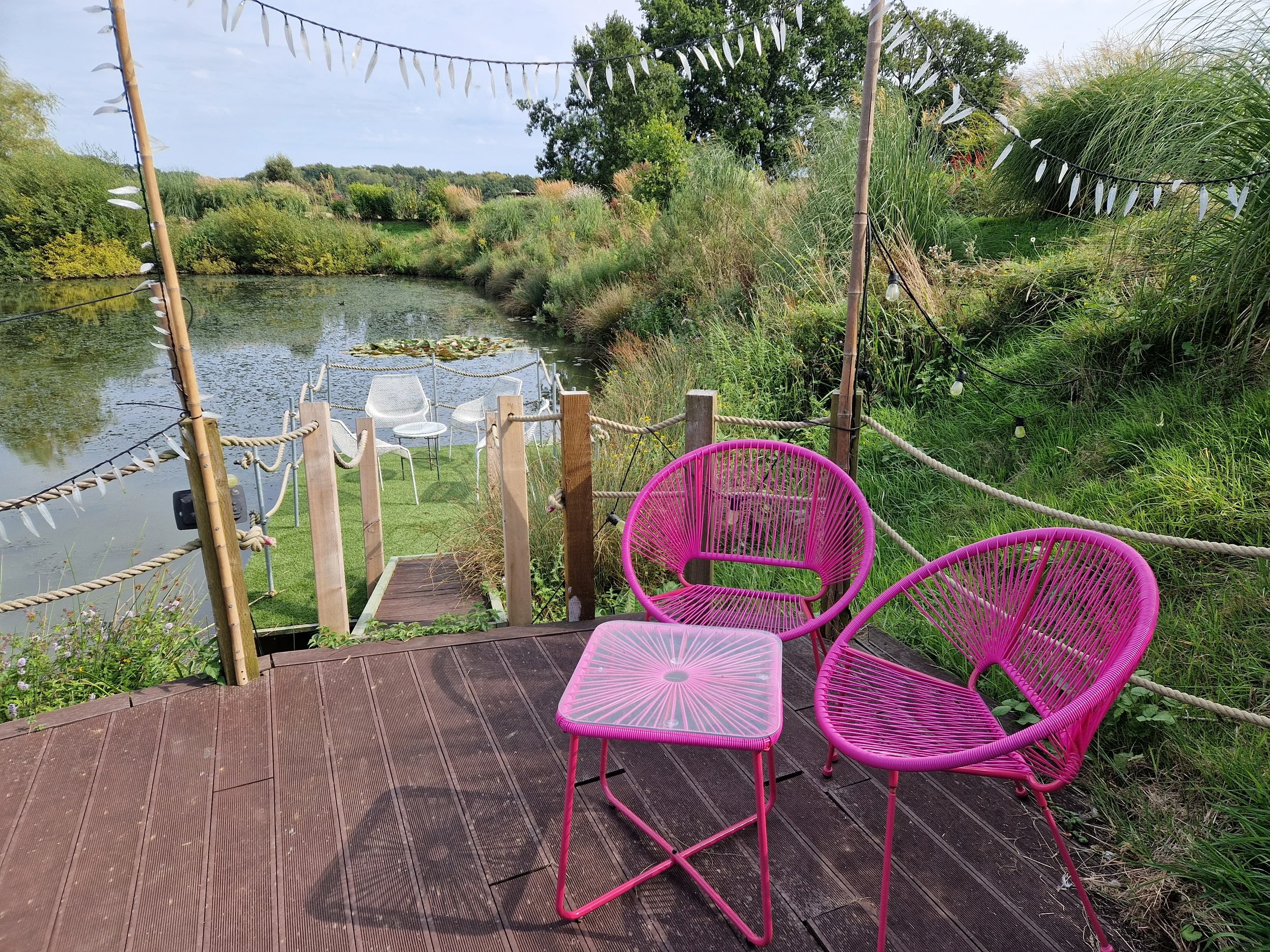 Outdoor seating next to the lake at our private spa in Sussex