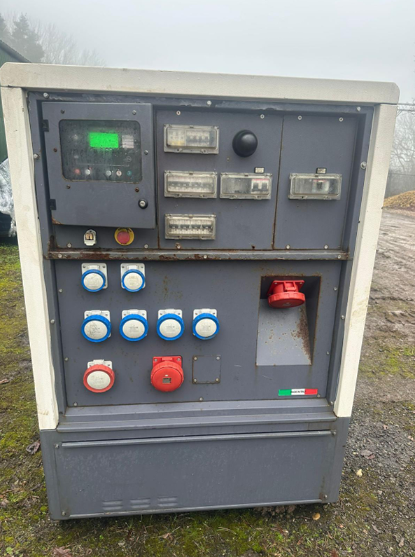 Outdoor electrical control panel with various switches, circuit breakers, and outlets, mounted on a weathered metal surface.