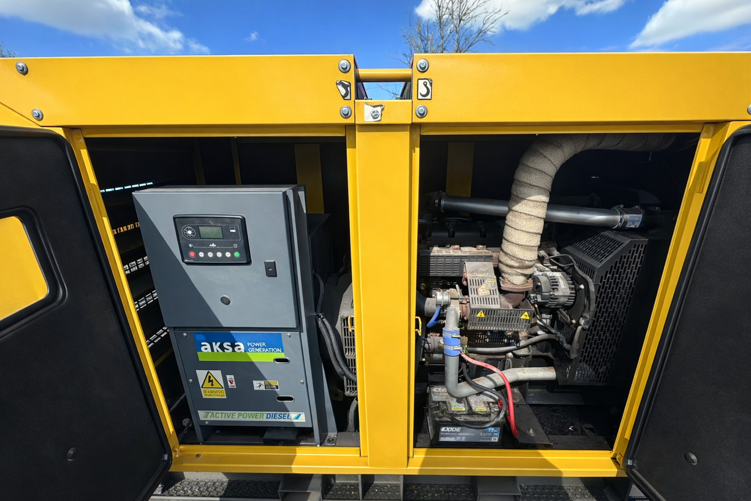Open yellow generator with control panel, engine, and exhaust pipe inside
