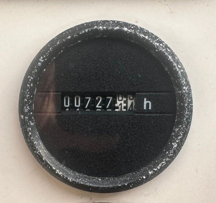 Close-up of a black, round mechanical hour meter showing 0727.5 hours on a white background.
