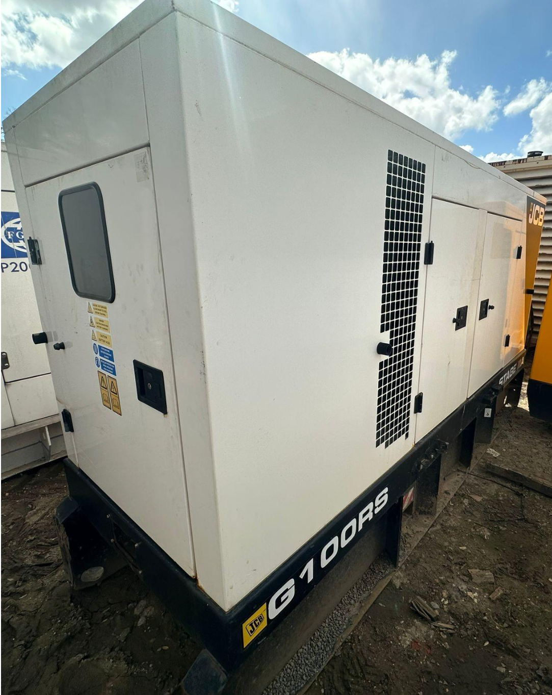 A large white JCB G-Loader industrial generator on a black trailer, outdoors under a partly cloudy sky.