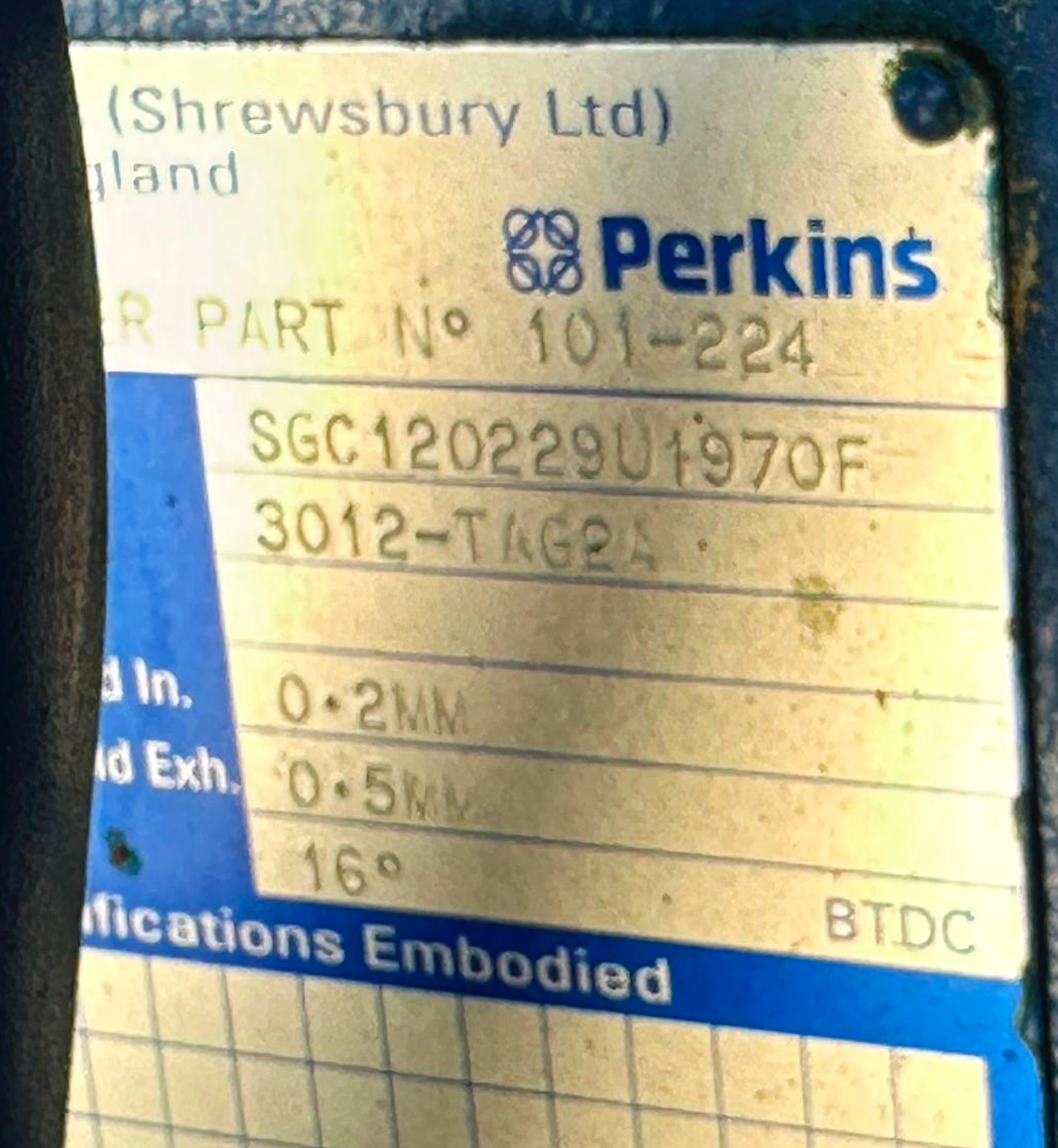 A metal label on a Perkins engine showing model and serial number details.