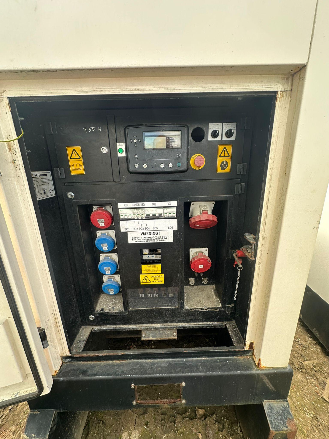 Electrical control panel with switches, buttons, and safety labels, enclosed in a metal cabinet.