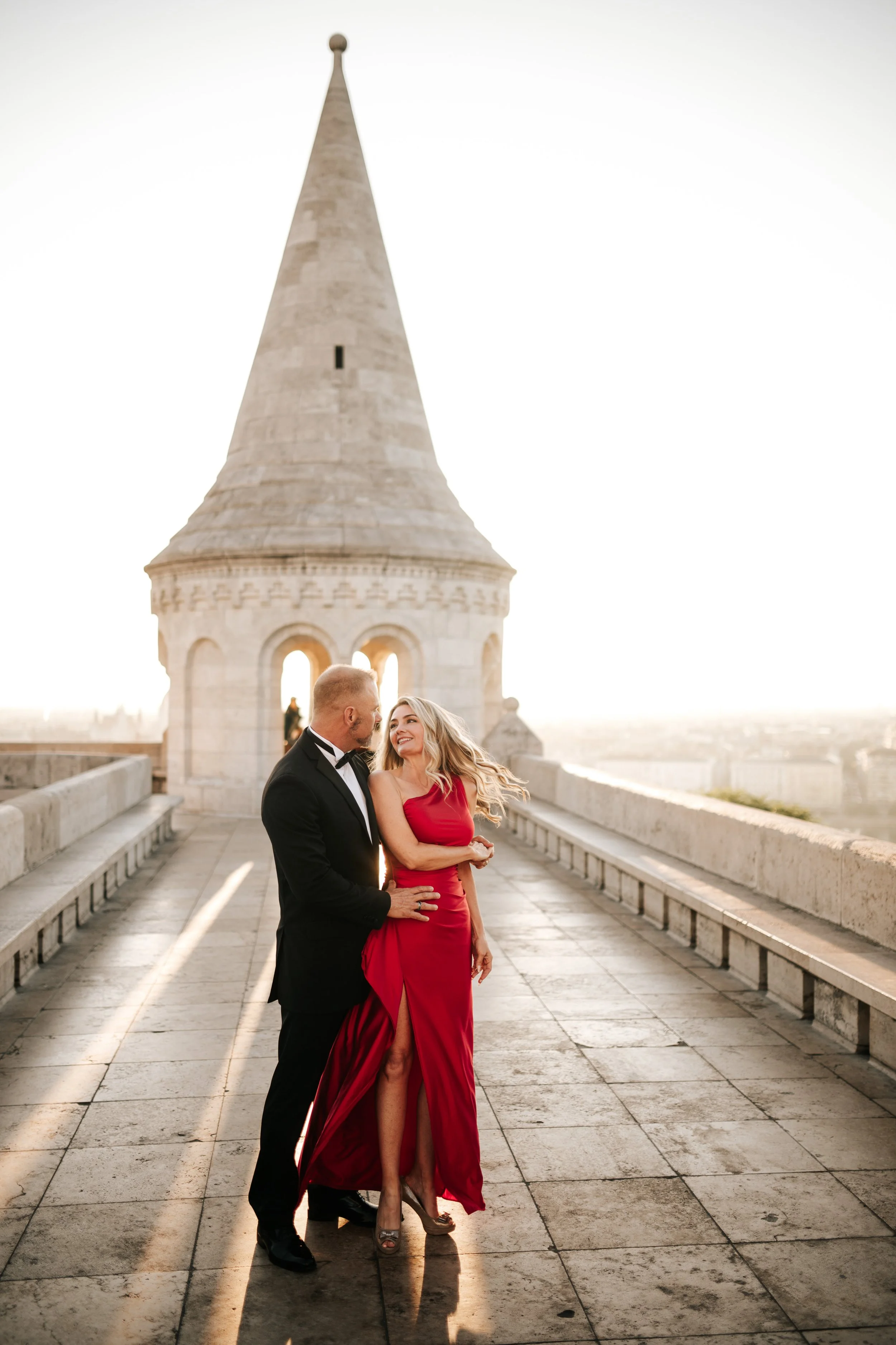 An embrace beside the stone balustrade, with a Fisherman’s Bastion tower behind them