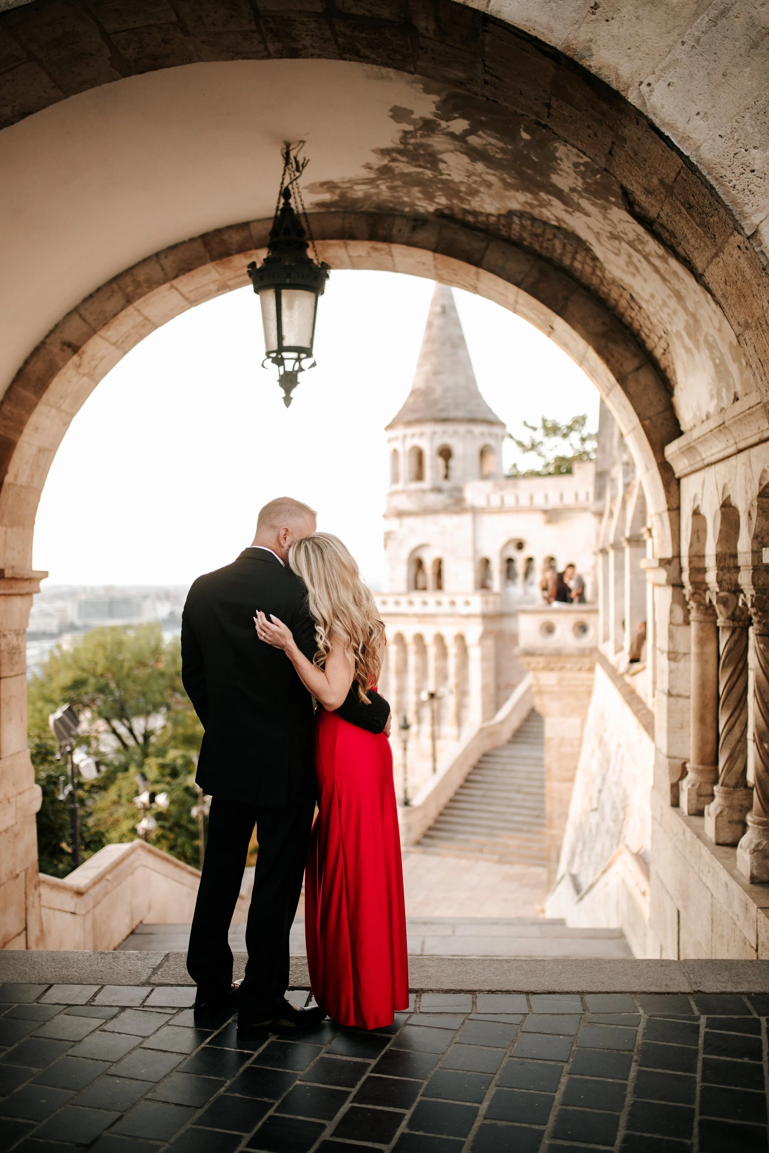 An embrace beneath the archway overlooking the staircase and towers