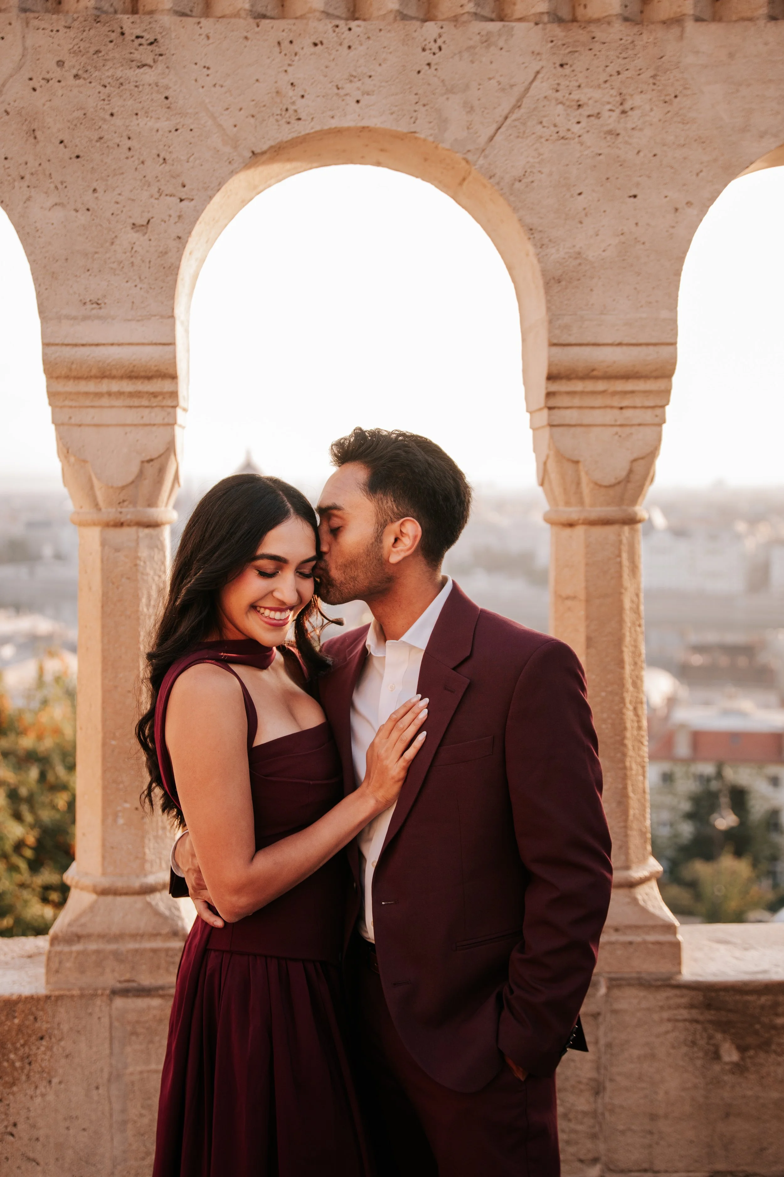 He kisses her forehead as she rests her hand on his jacket