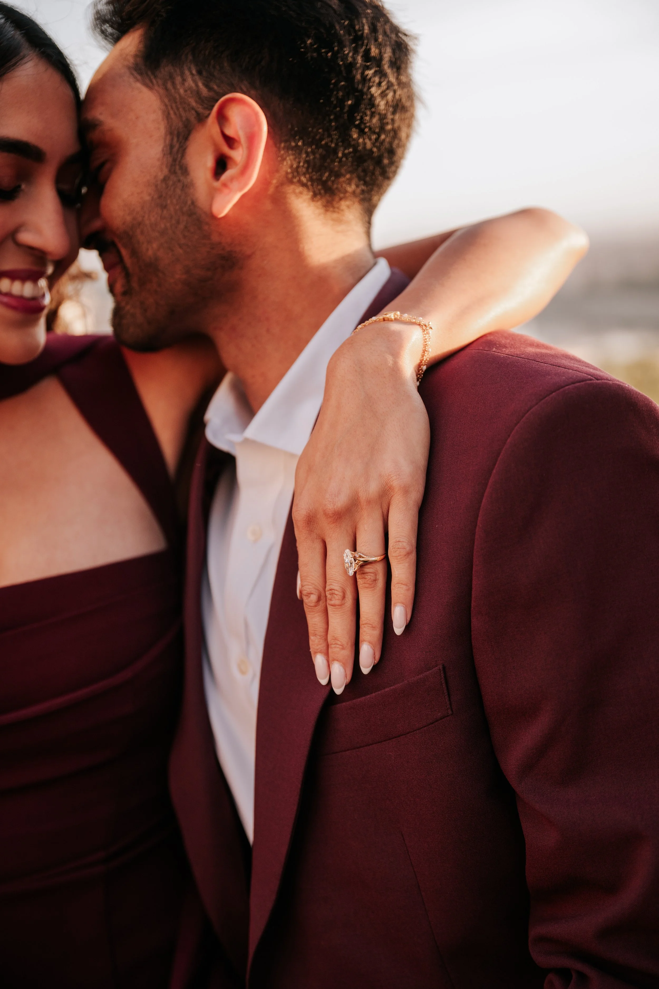 Close-up of her ring as she wraps her arm around his shoulders