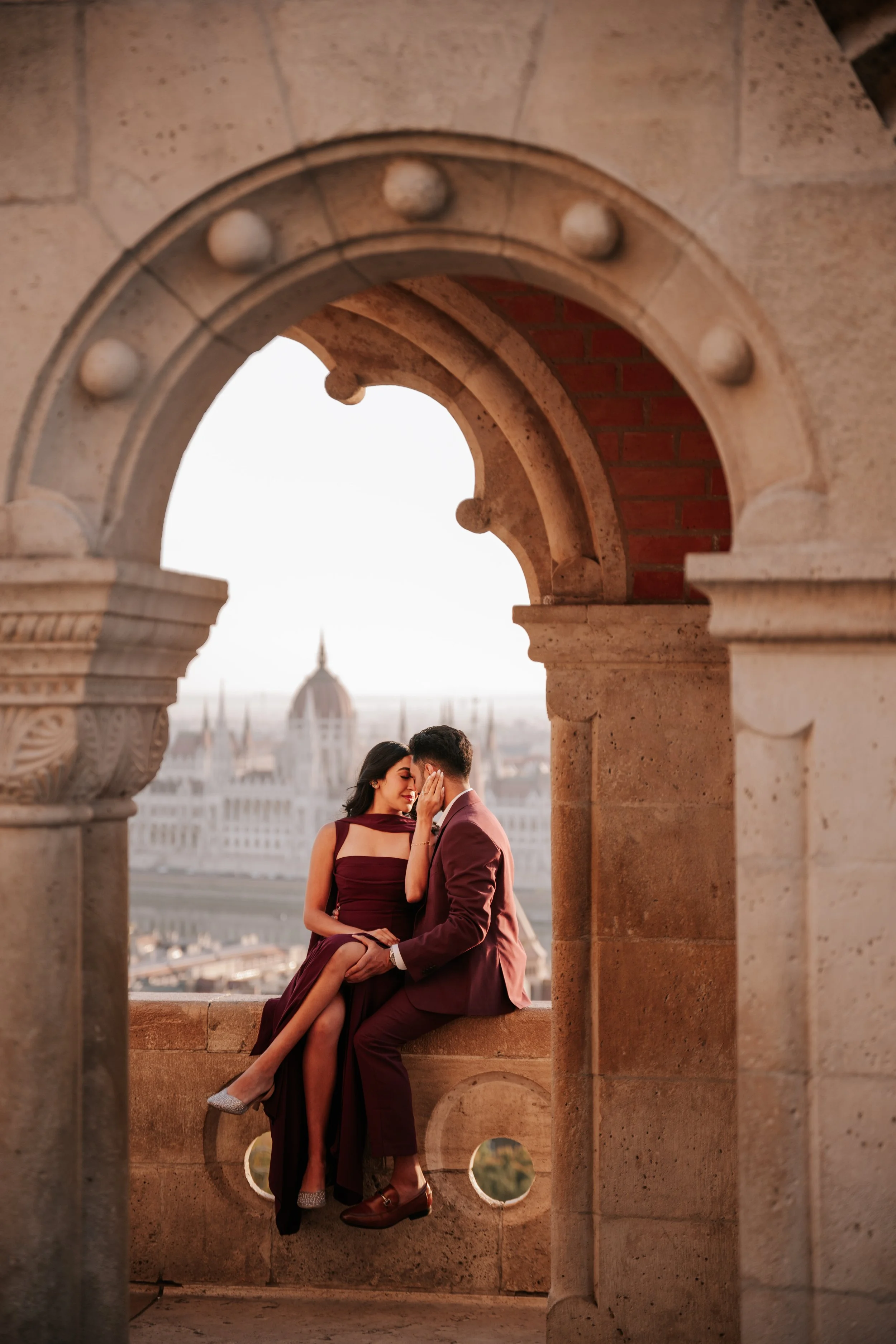 A kiss while sitting in a stone window overlooking the Hungarian Parliament