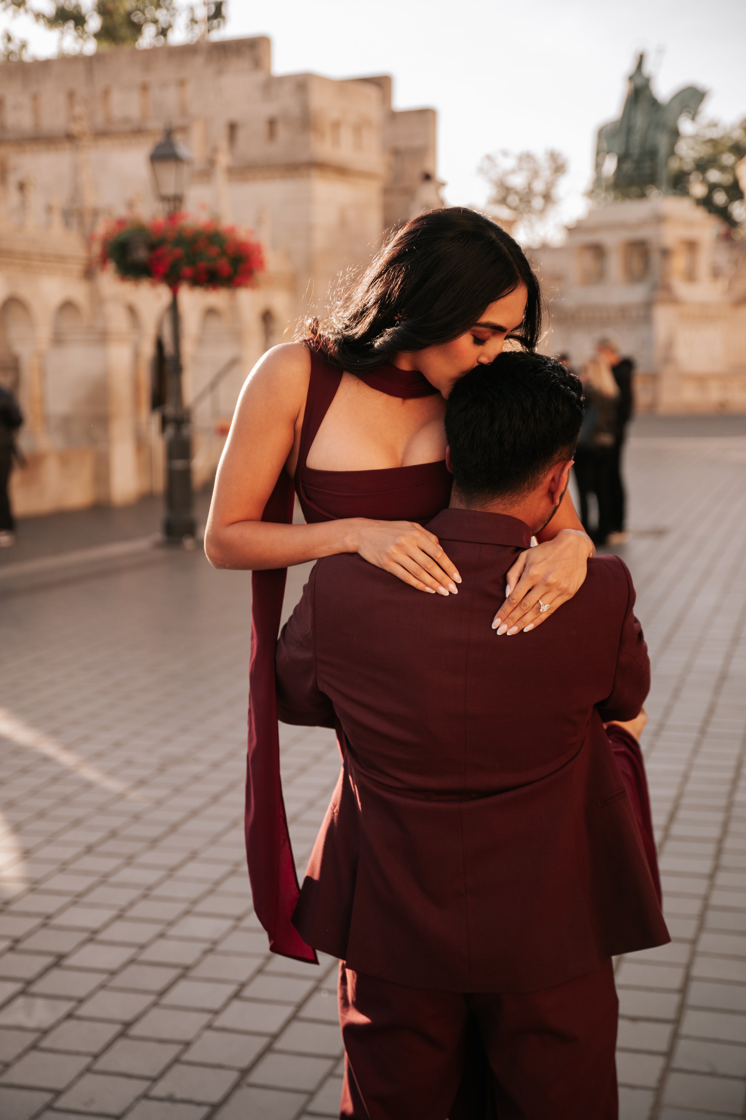 He lifts her into his arms on the cobbled terrace