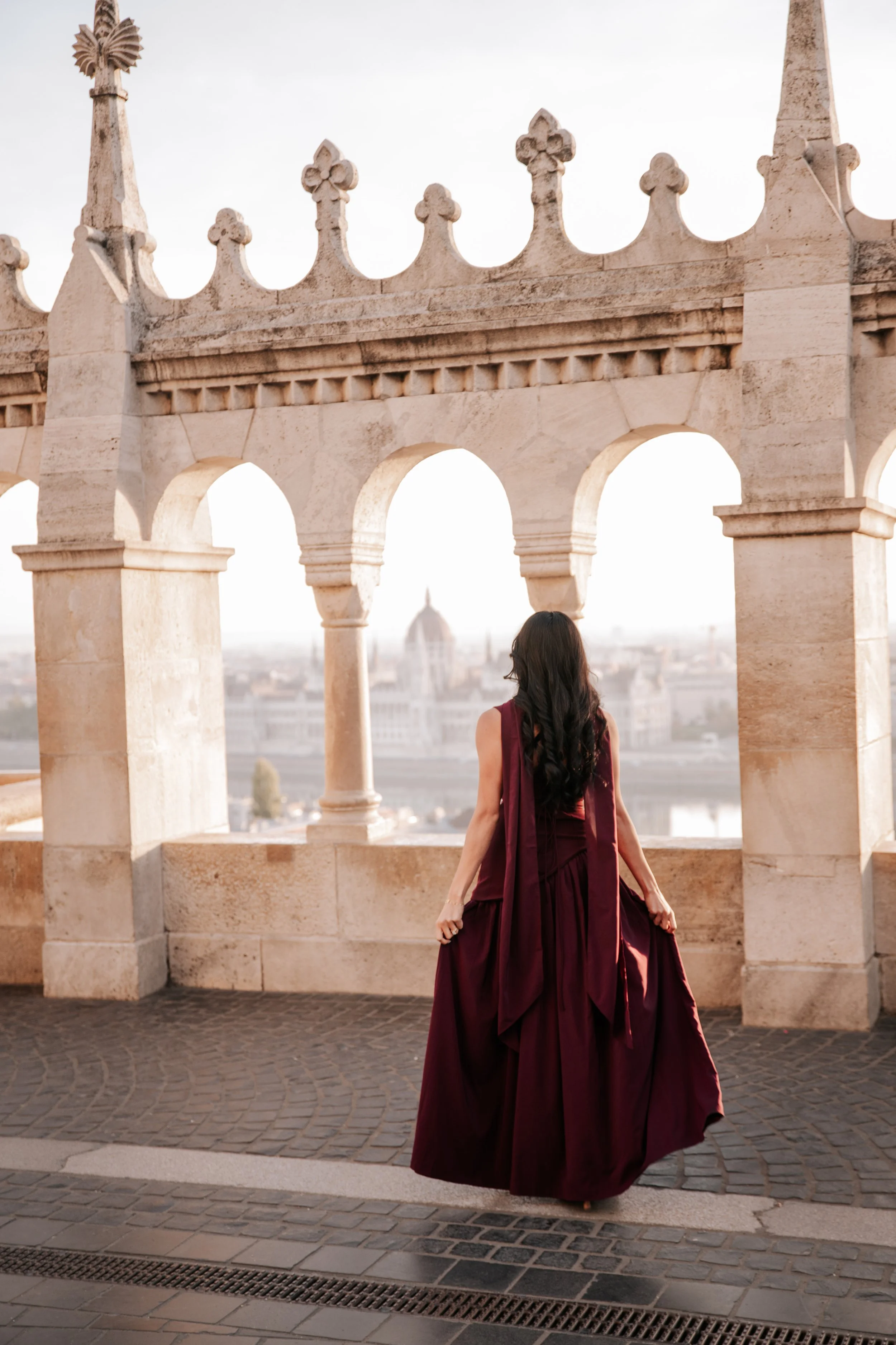 Her burgundy dress from behind, framed by the arches of Fisherman’s Bastion