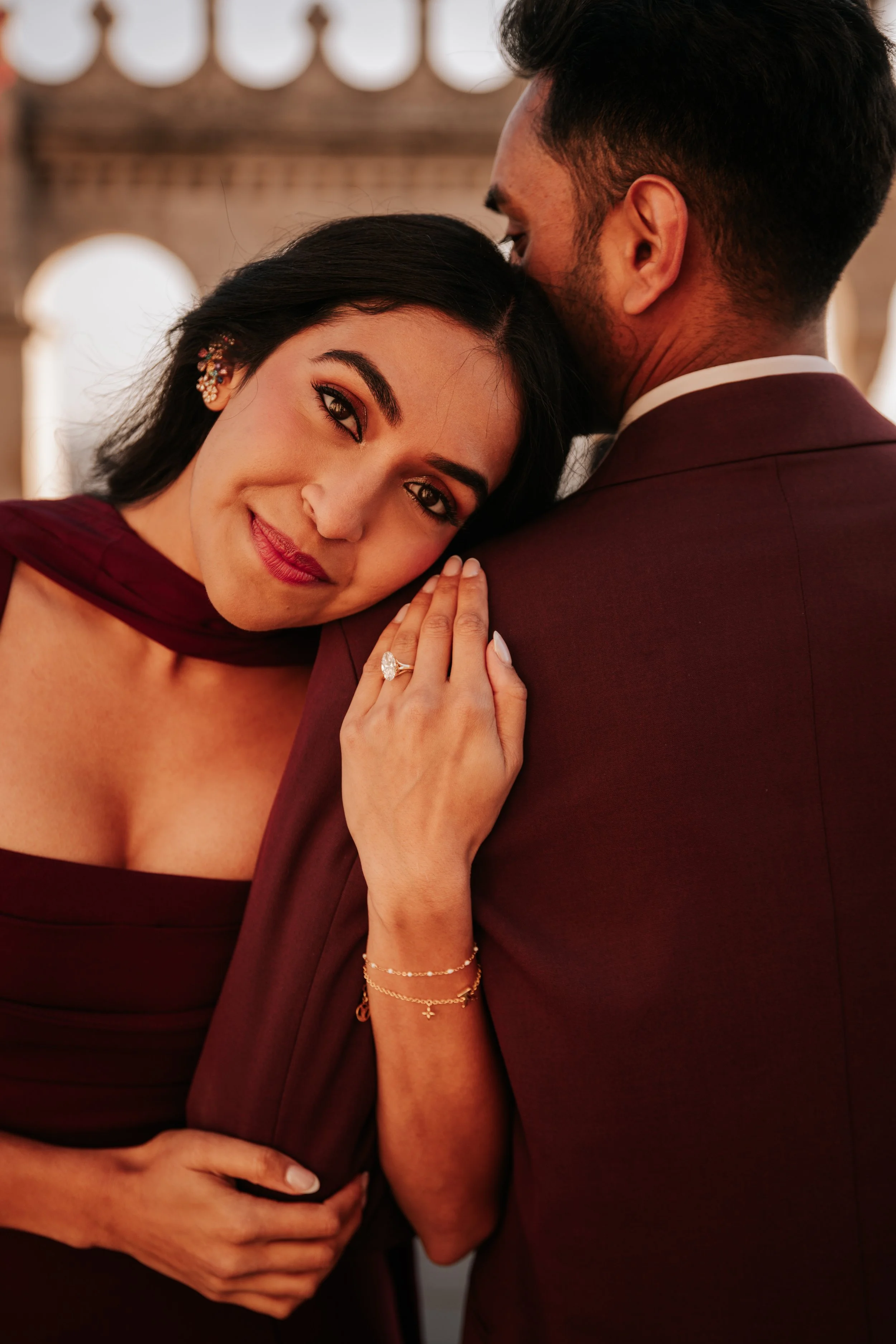 She rests her head against his shoulder, her ring visible on his jacket