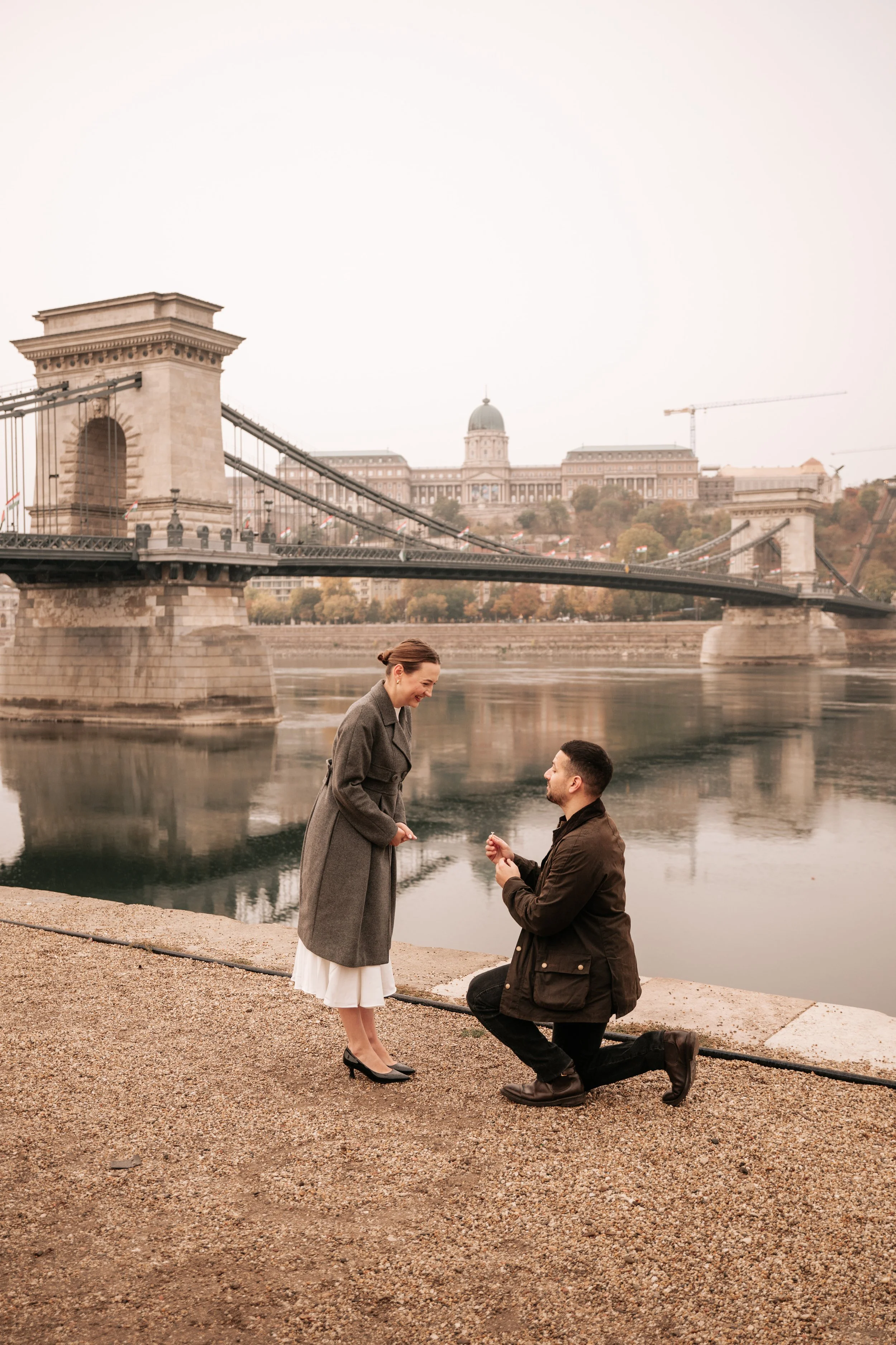 Surprise proposal photography in Budapest — down on one knee beside the Chain Bridge