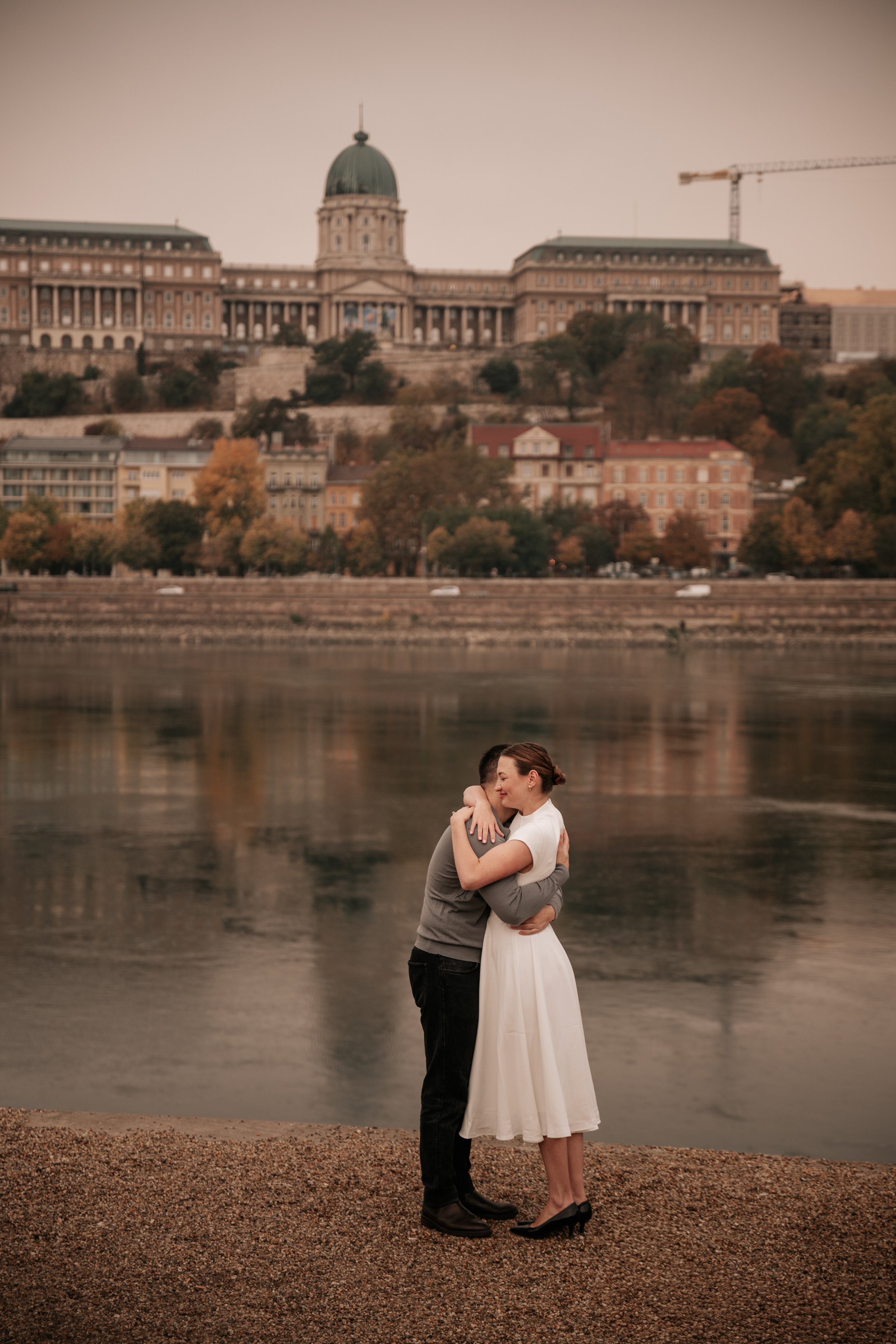 An engagement portrait beside the Danube with Buda Castle in the background