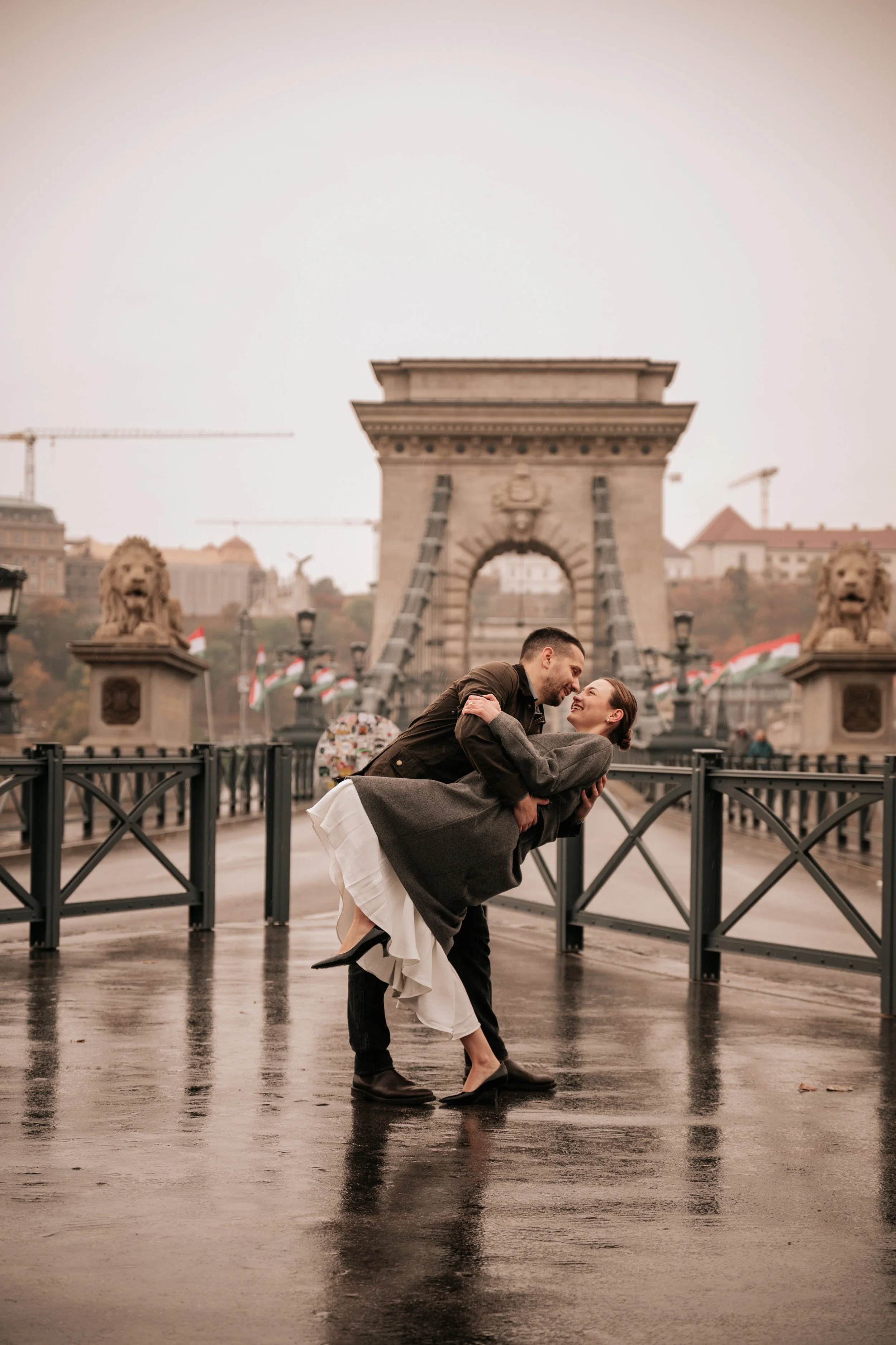 A dip and a kiss at the Chain Bridge during their engagement photoshoot