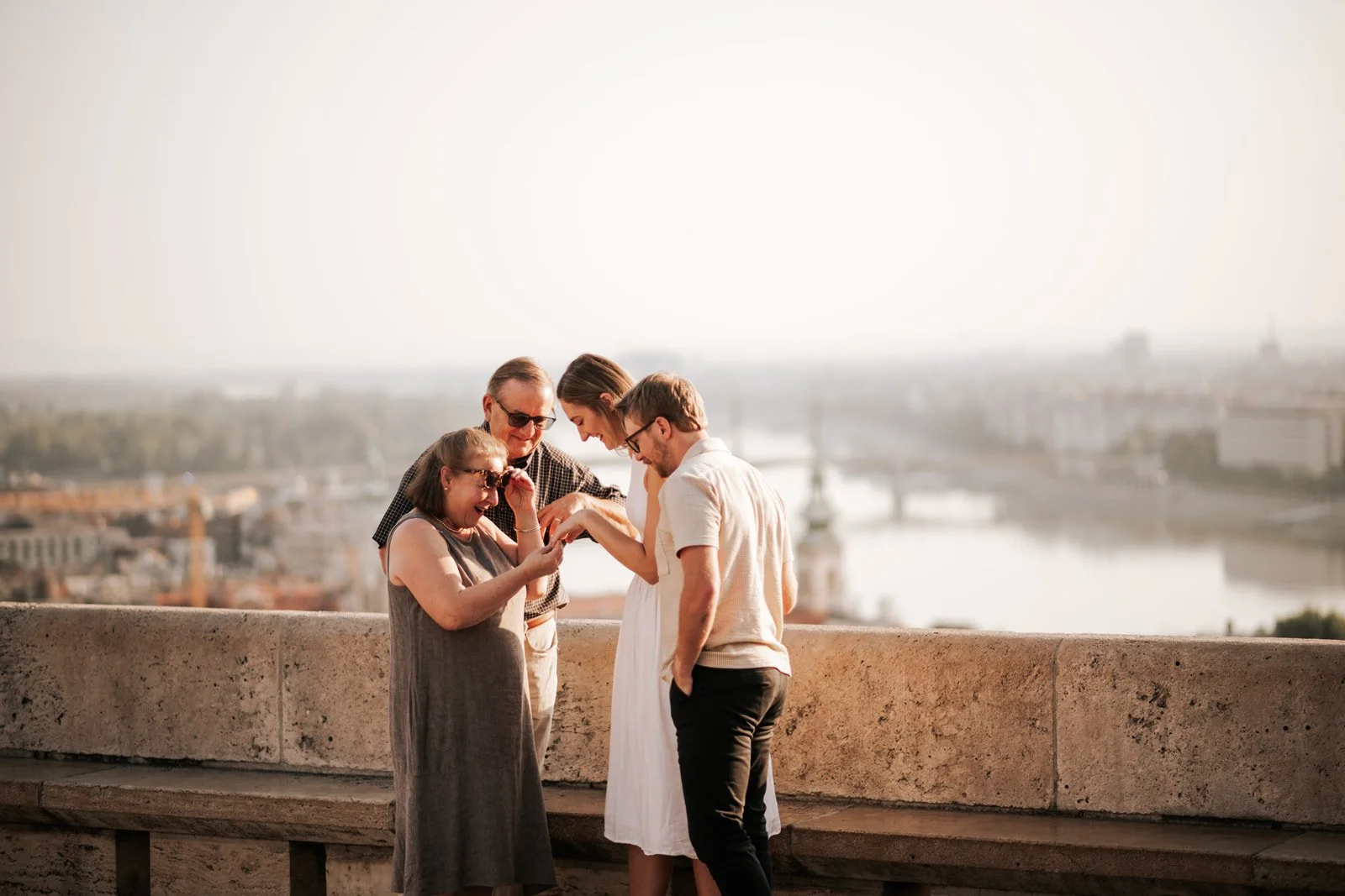 Family checking her ring after a surprise proposal in Budapest