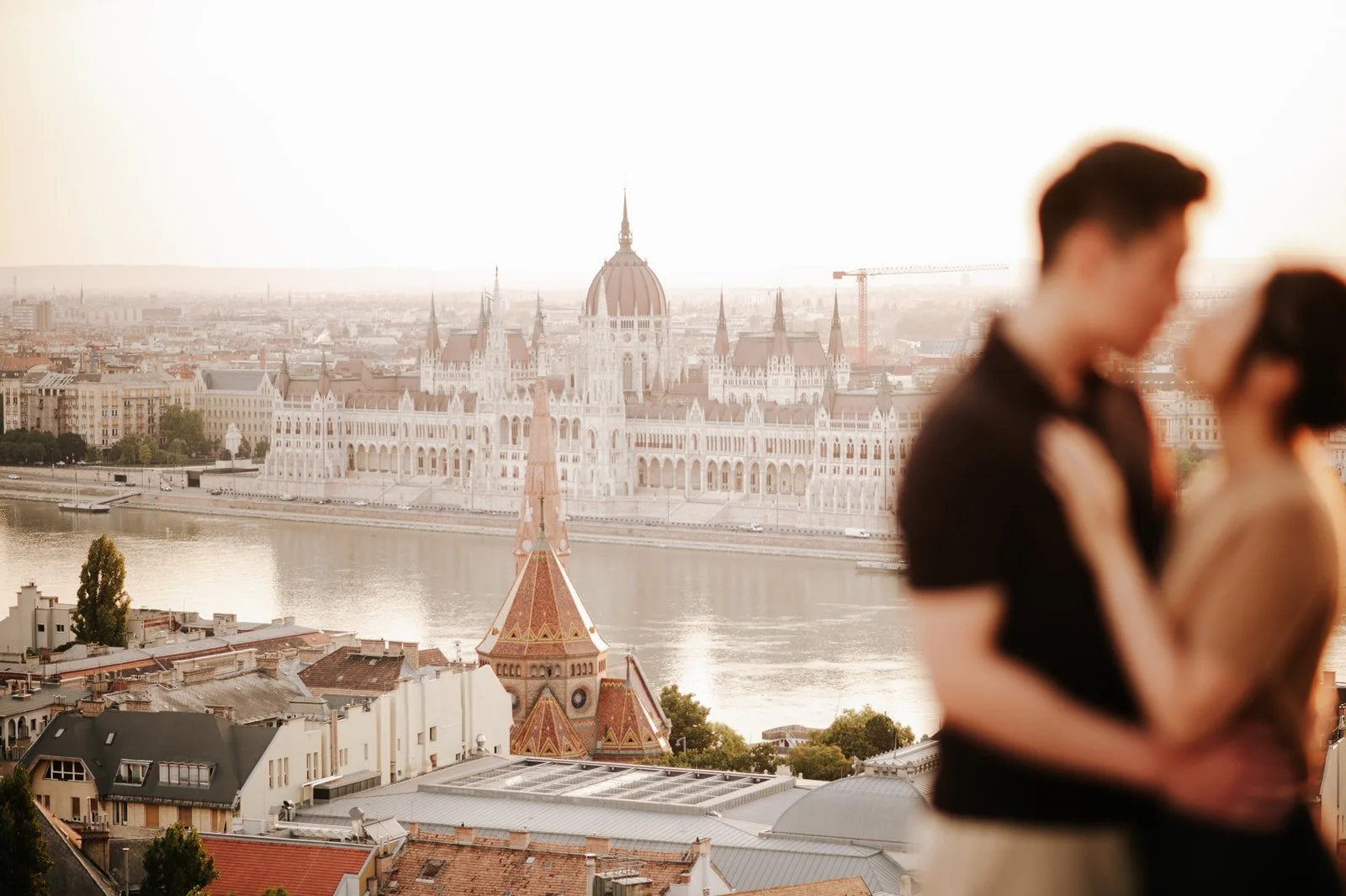 couple in the foreground with a clear panoramic view of the Budapest Parliament in the background