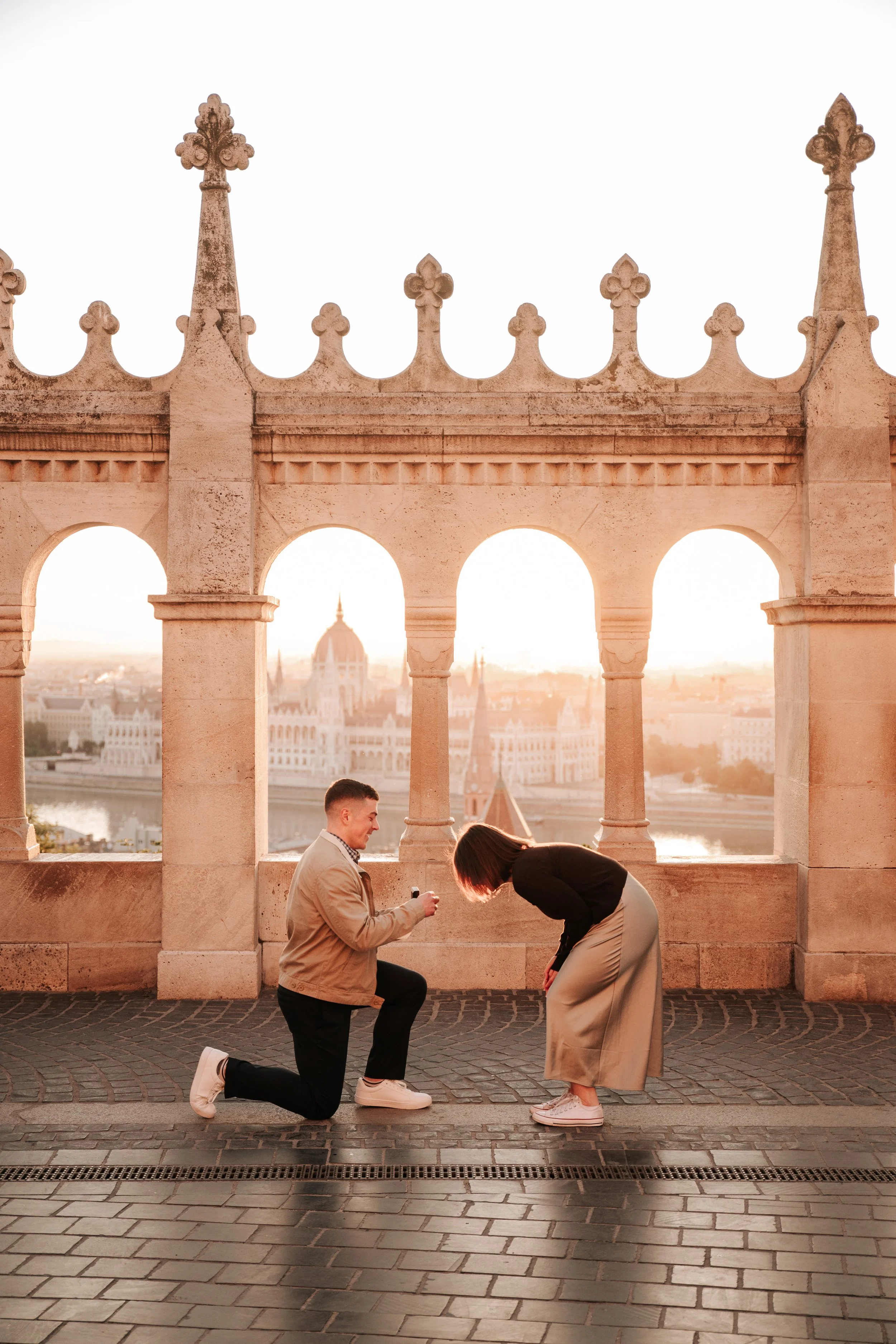 Marriage proposal framed by the arches of Fisherman's Bastion at sunrise