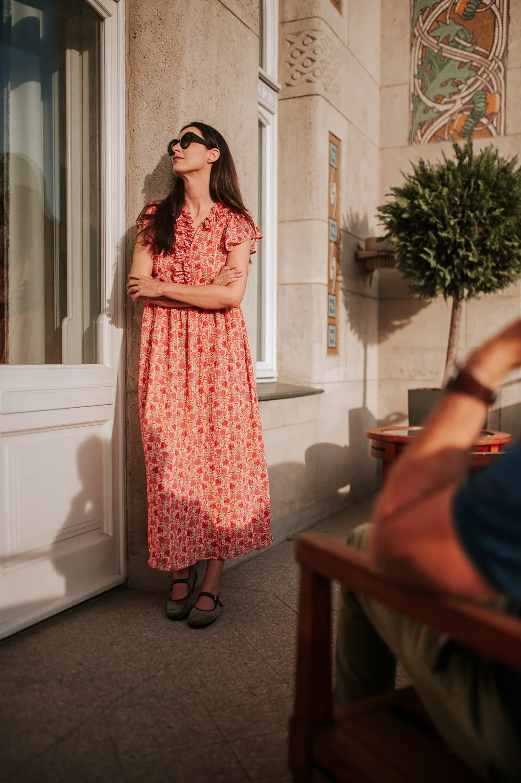 Woman in a peach dress on the balcony of the Four Seasons Gresham Palace Budapest — elegant lifestyle photo in a luxury hotel setting.