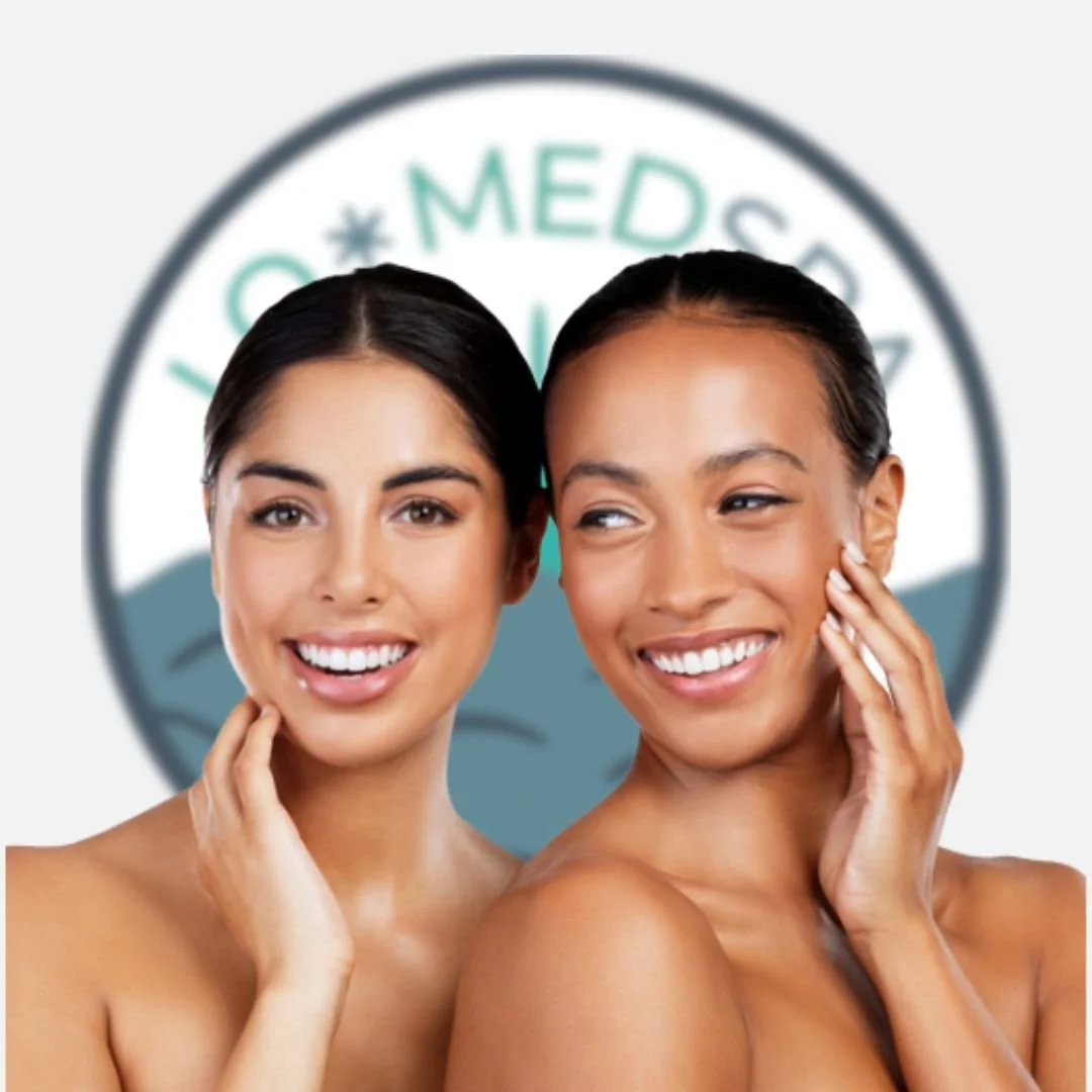Two women smiling with clear skin and natural beauty, standing in front of a blurred medical or skincare logo.