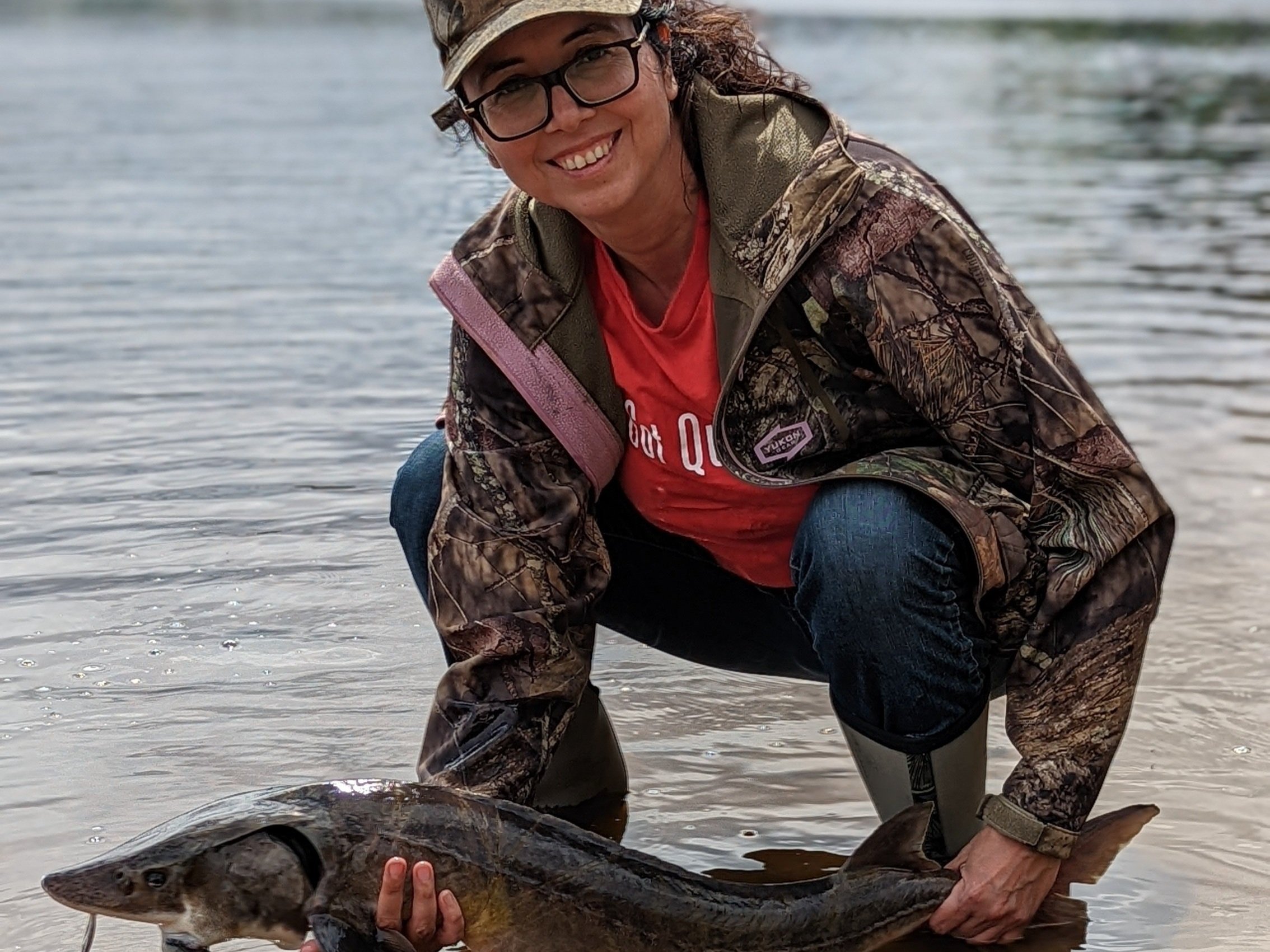 Jennifer Simard (Moose Cree First Nation) releases a lake sturgeon in the Mattagami River. 