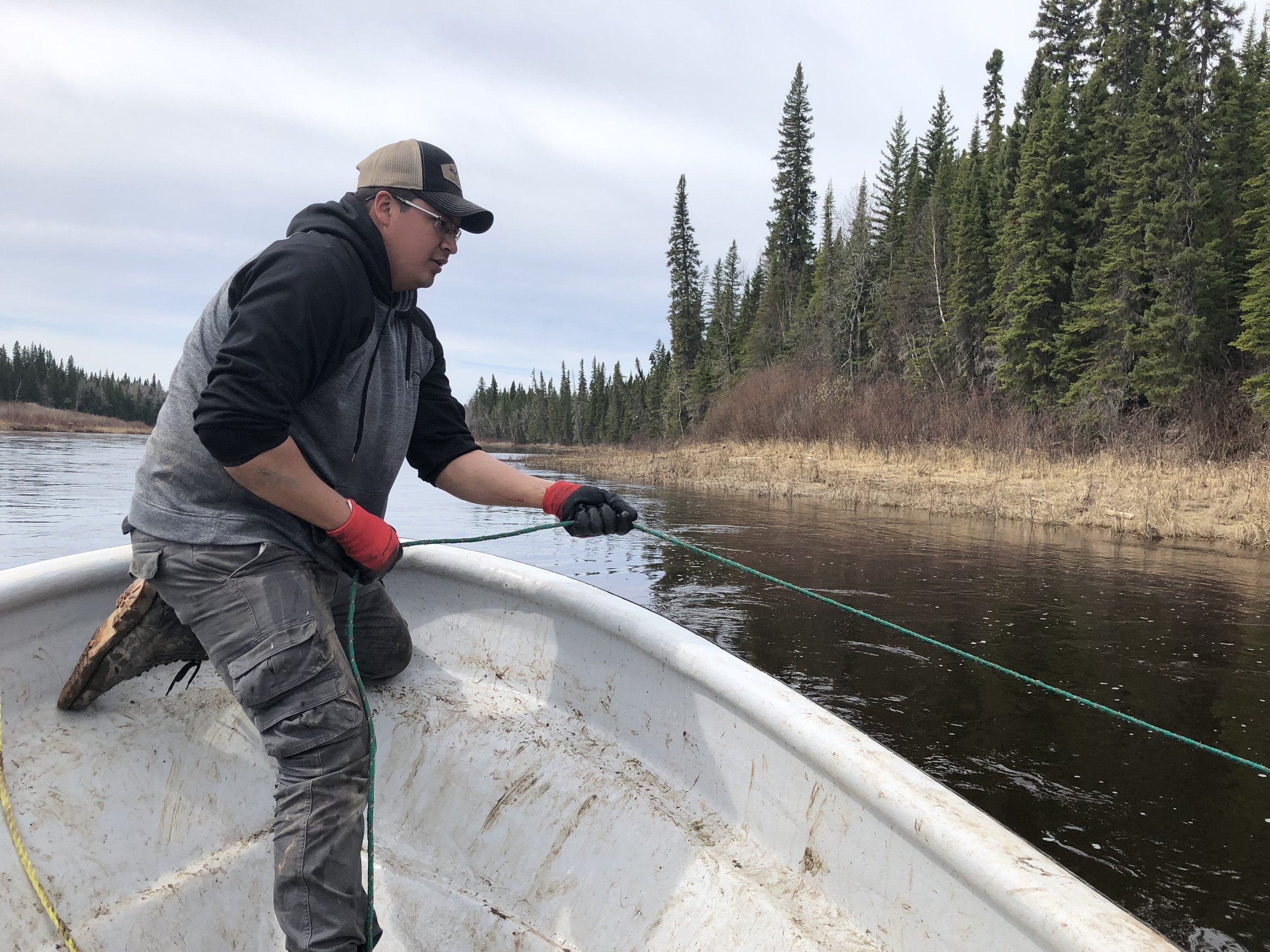 Warren Iserhoff (the  new Environmental Youth Coordinator with MCFN Resource Protection) grapples for an underwater receiver. Receivers listen for the tagged lake sturgeon. 
