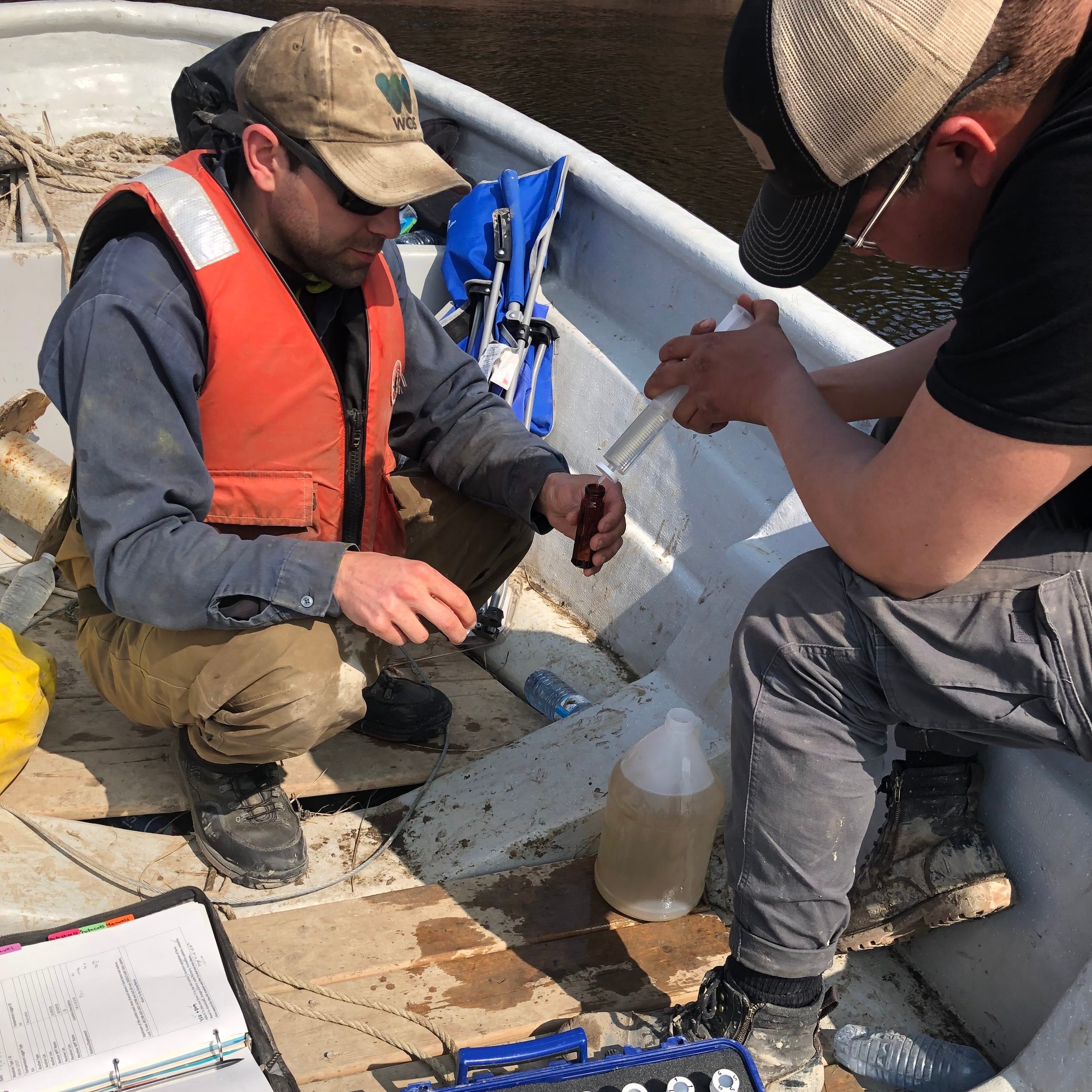 Jacob Seguin (left, WCS Canada) and Warren Iserhoff (right, MCFN Resource Protection) take water samples on the North French River to monitor water quality where namew are swimming