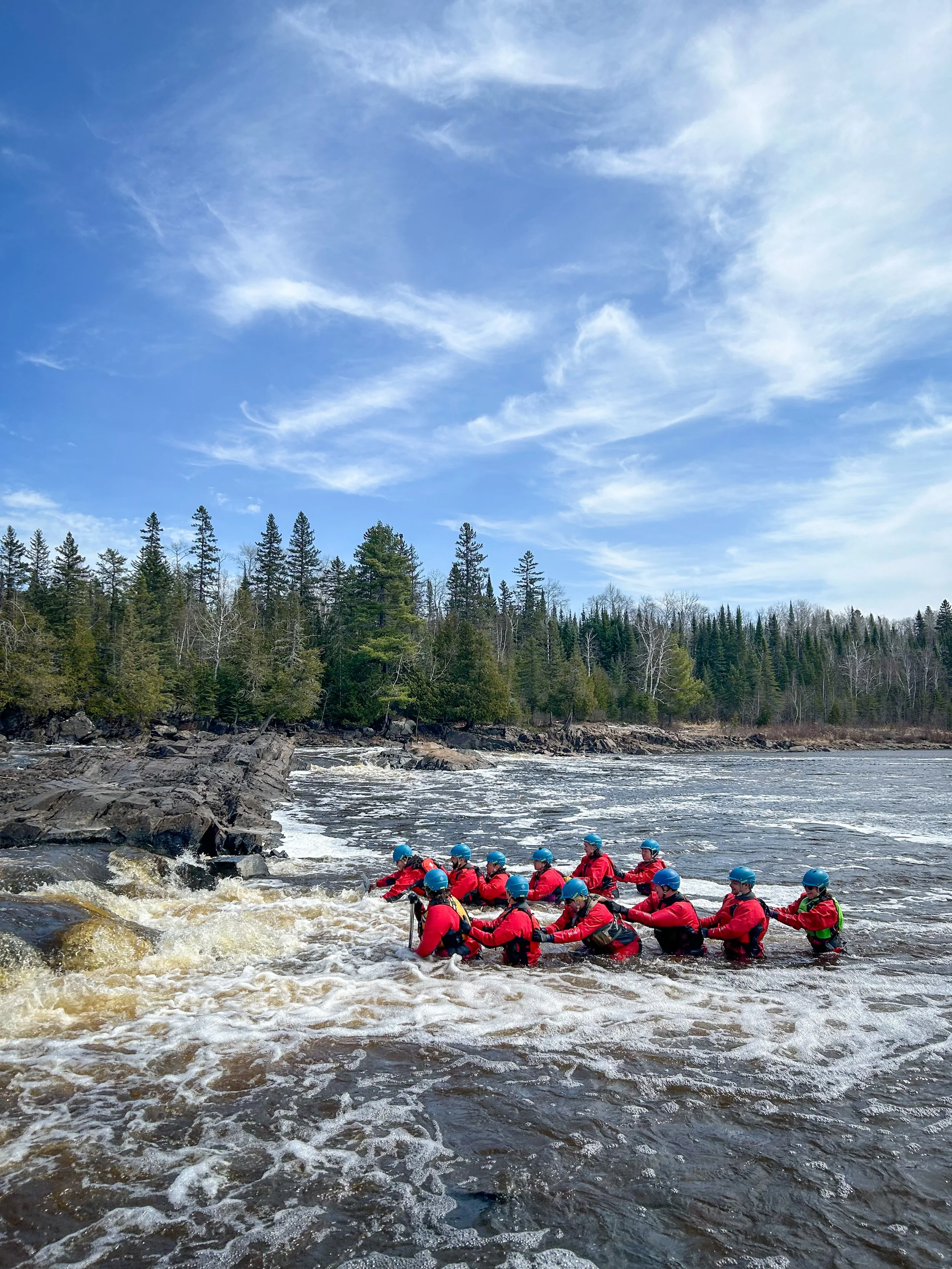 Everyone practices crossing fast-moving shallow water