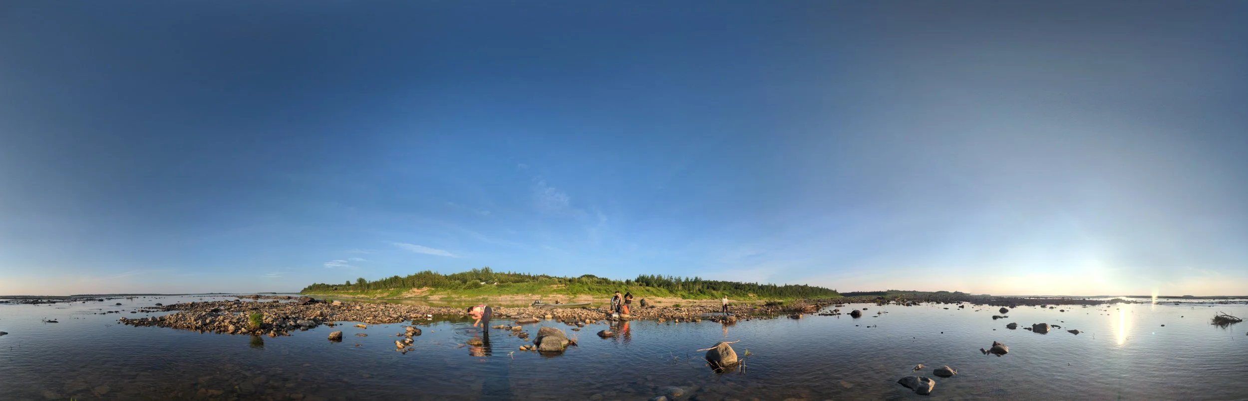Youth and others in shallow water near shore benthic sampling