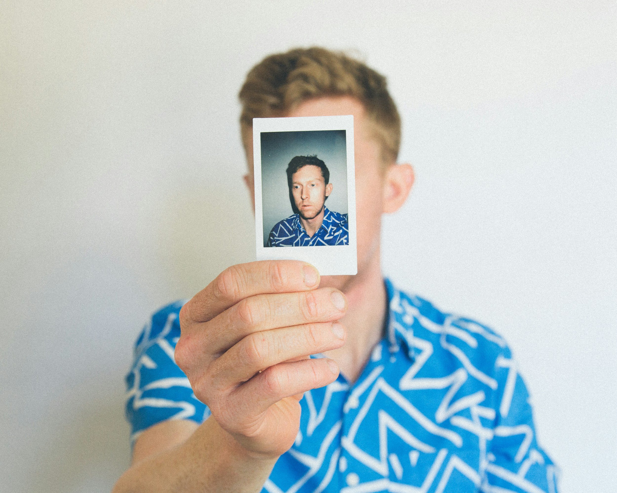 a man with a picture of himself trying to find his identity