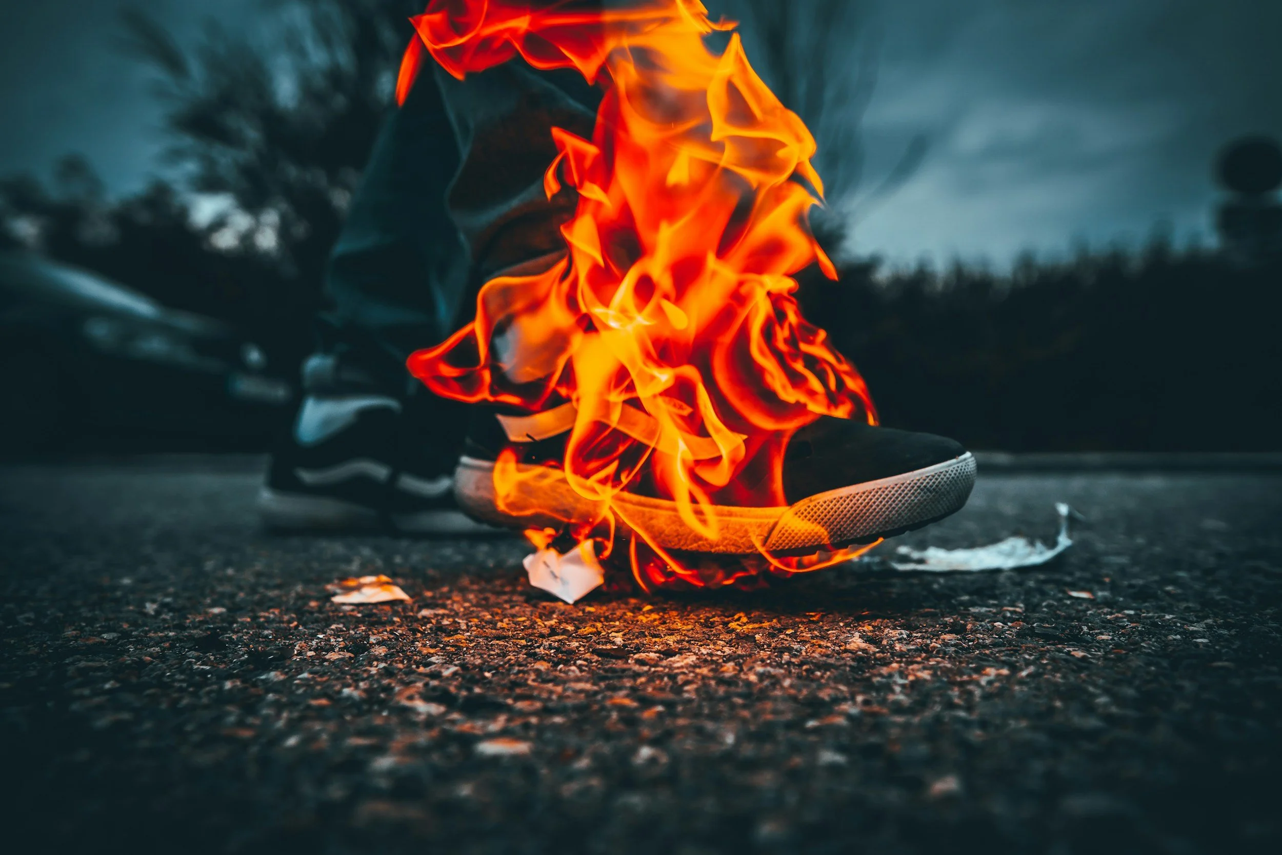 a foot on fire, symbolizing how people can self-destruct