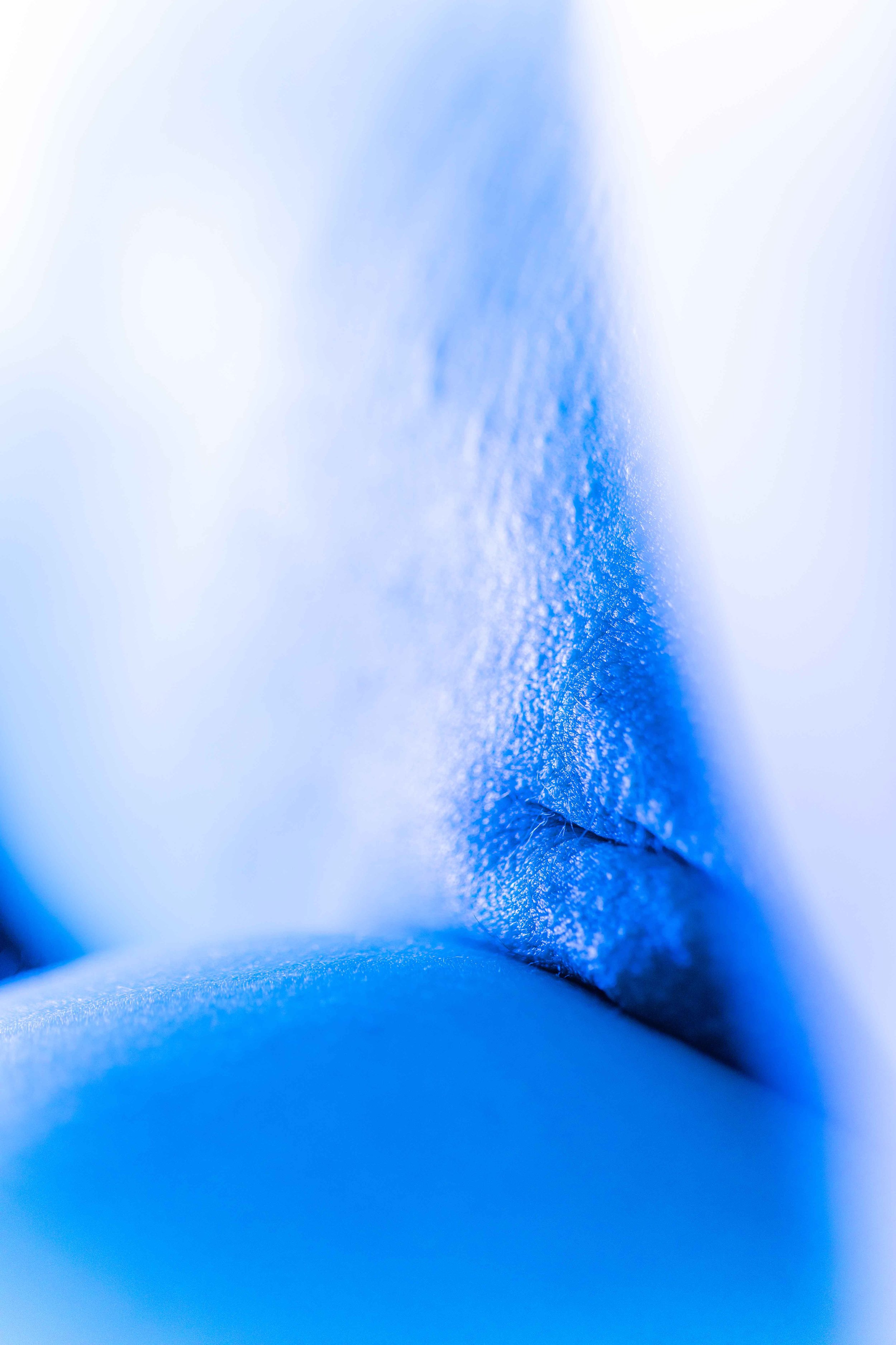 Zoom très rapproché d'une texture de peau bleue avec des détails visibles, peut-être une peau artificielle ou un matériau synthétique coloré en bleu.