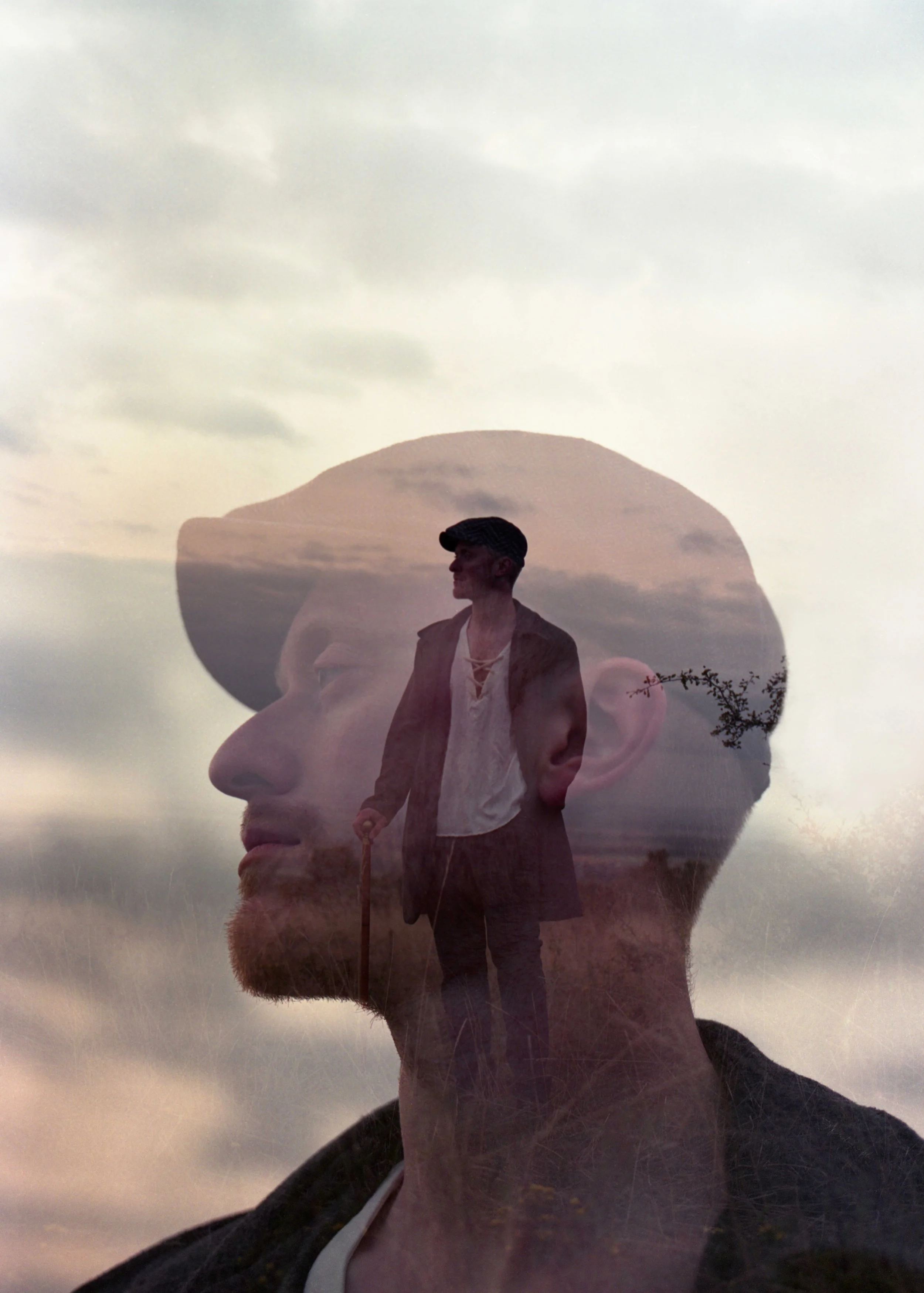 Double exposition d'une silhouette masculine avec un chapeau, un homme debout avec une canne et un paysage avec des nuages et des arbres en arrière-plan.