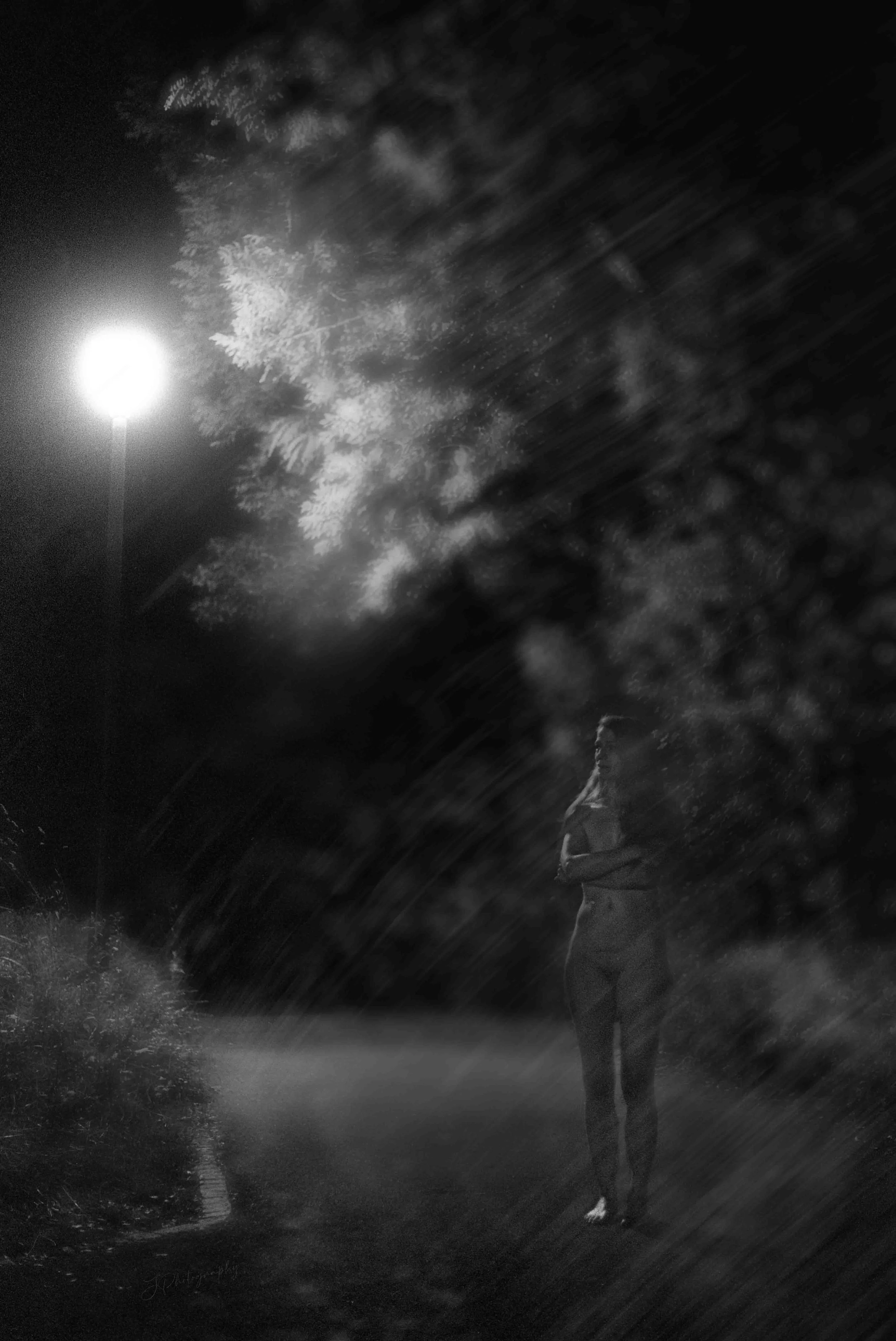 Une silhouette d'une personne seule, portant un sac à dos, debout sur un trottoir la nuit, sous un lampadaire.