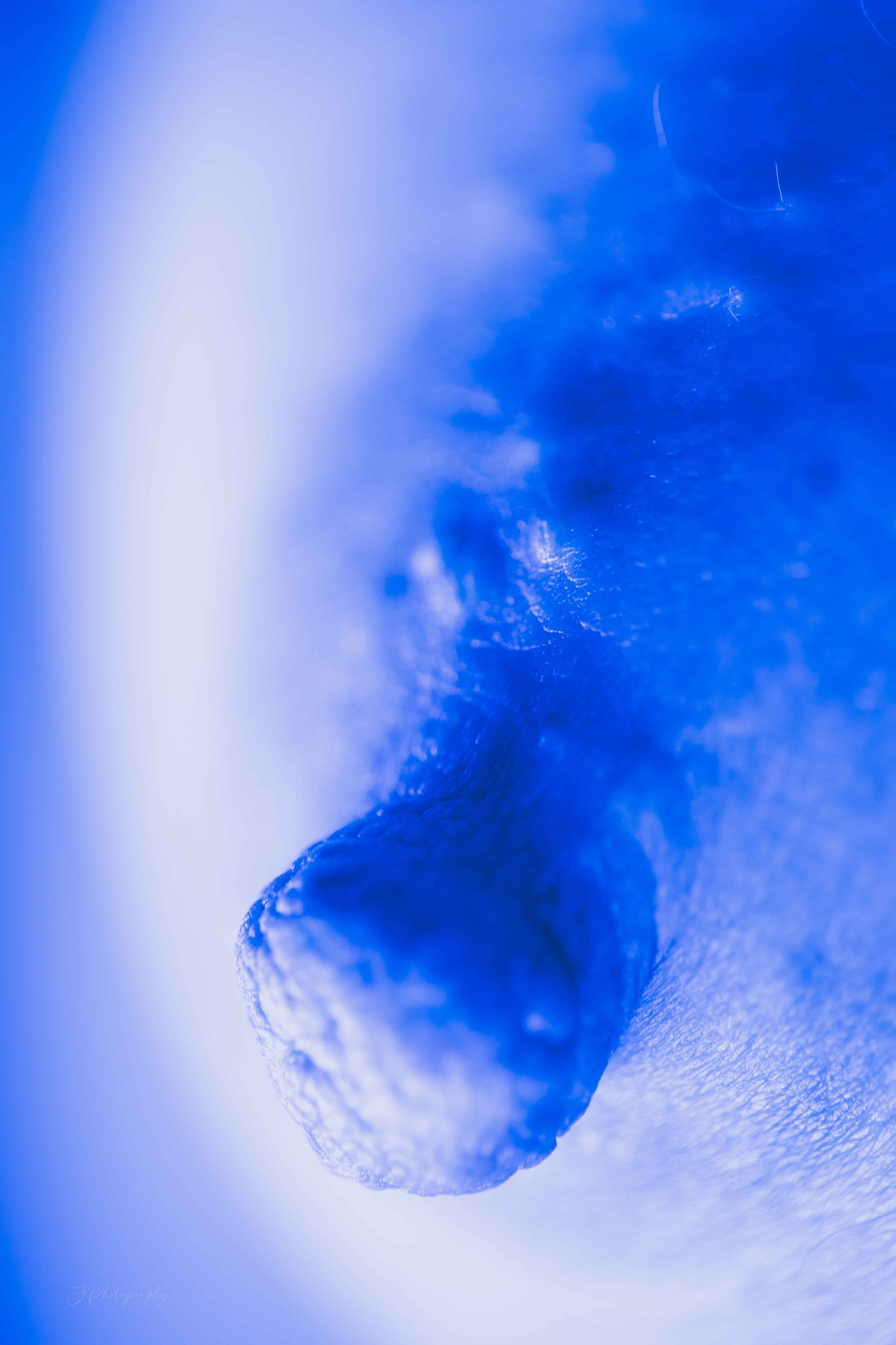 Une main de près tenant une boule de neige en vieux en hiver, avec un fond bleu flou.