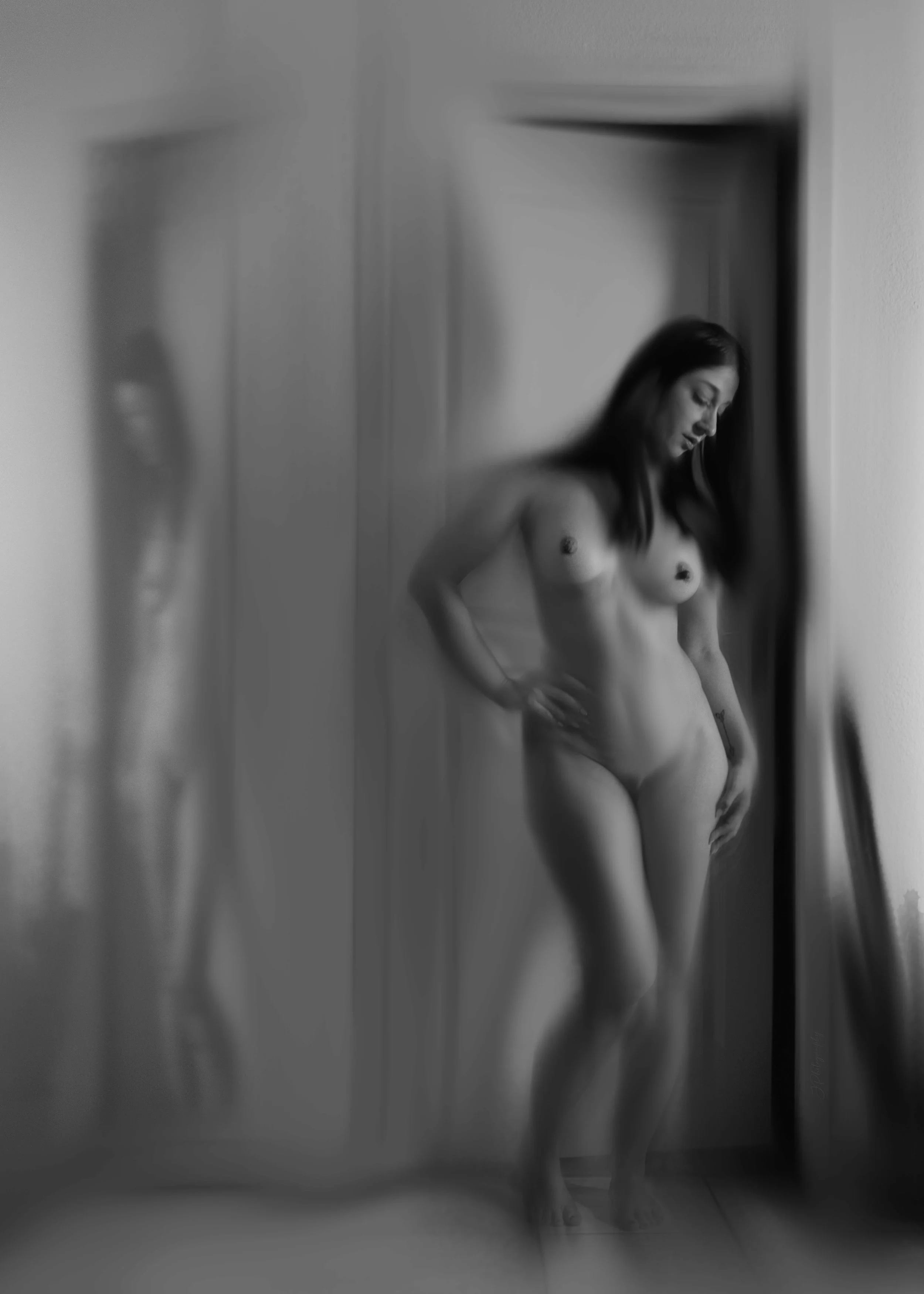 Une femme nue se regarde dans un miroir dans une pièce