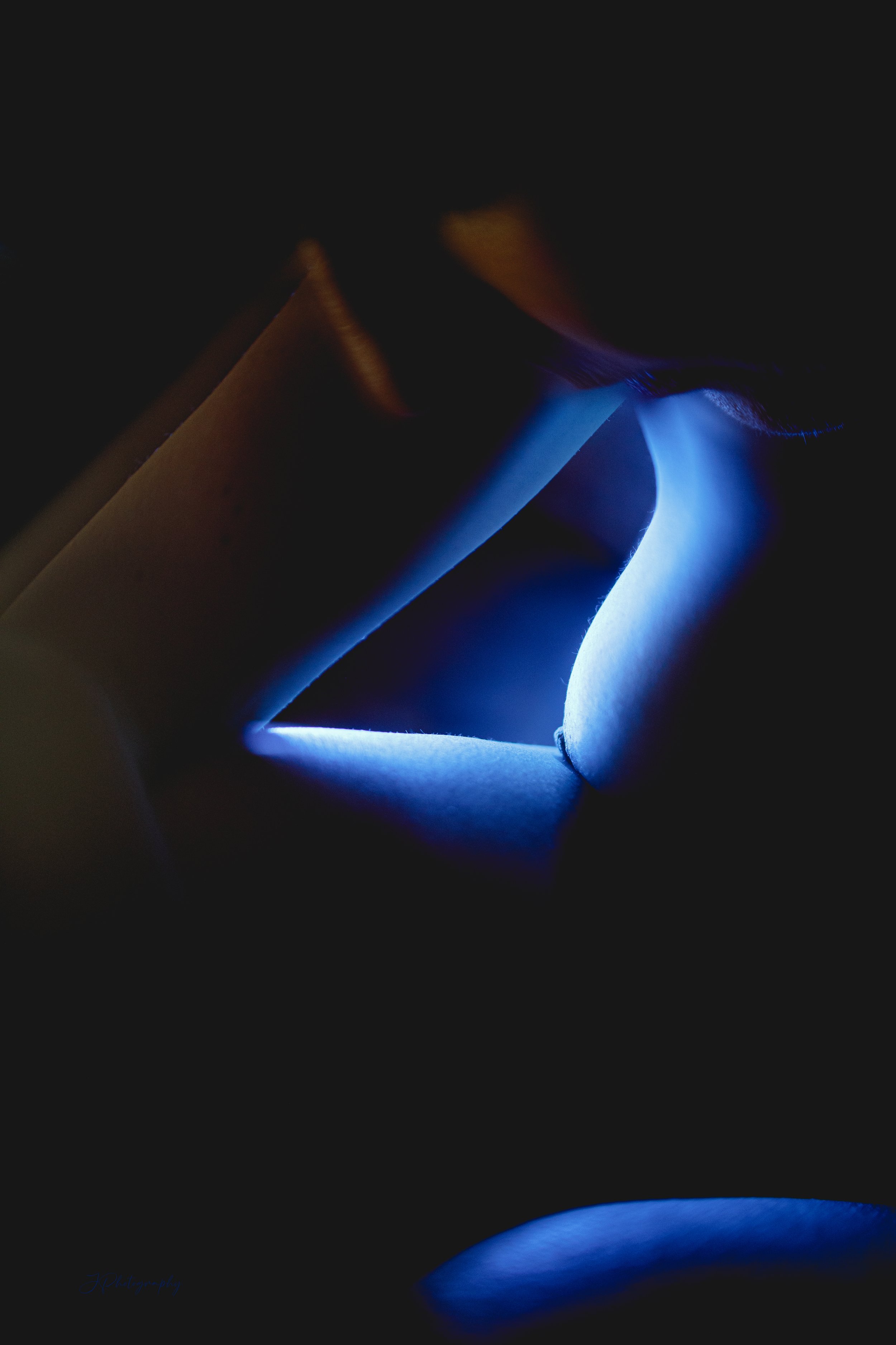 Détail d'une image colorée de bleu et de jaune, montrant une partie d'un visage et de la poitrine d'une femme nue.