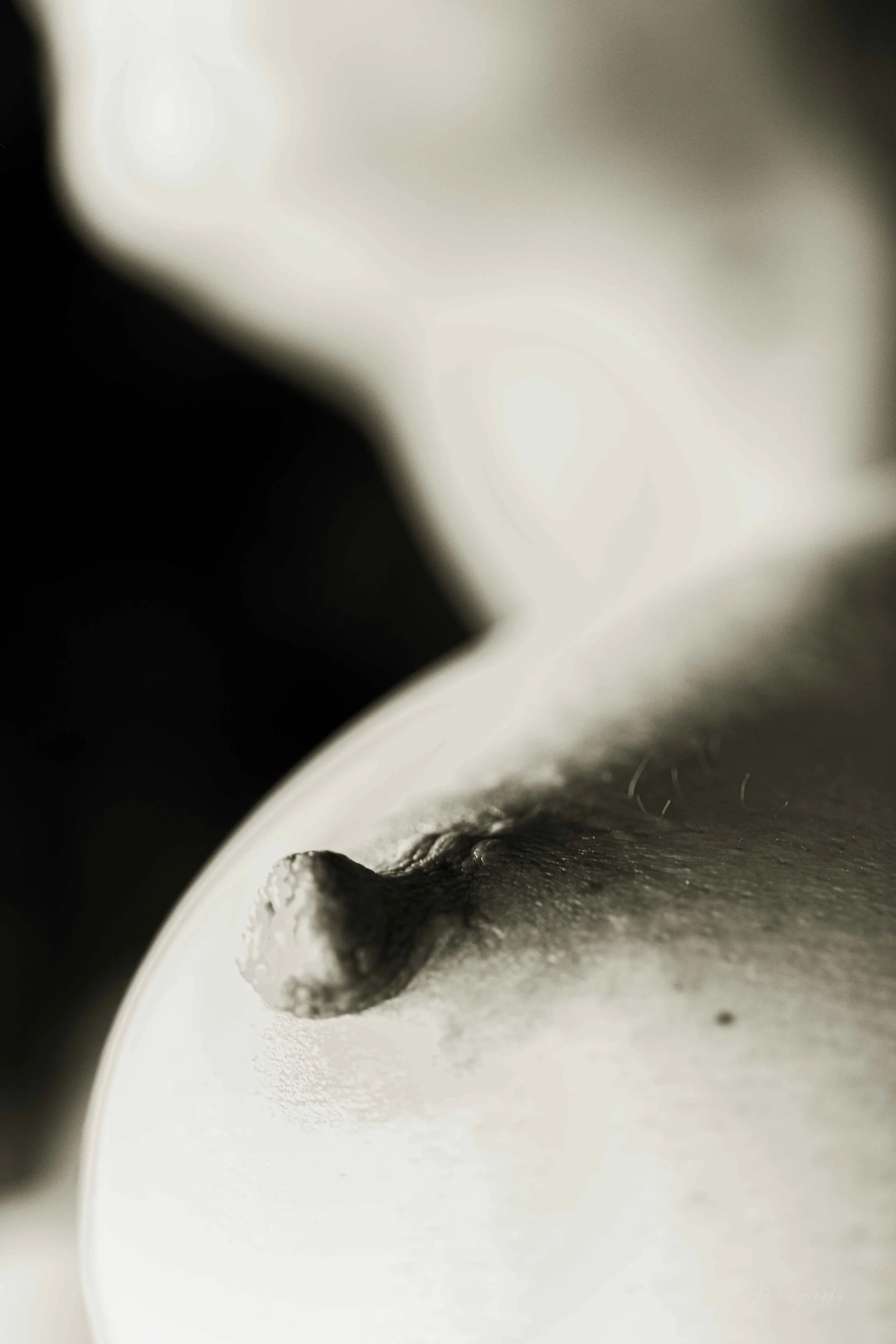 Gros plan d'une bougie blanche avec une mèche en cire fondu. L'image est en noir et blanc, avec un contraste marqué.