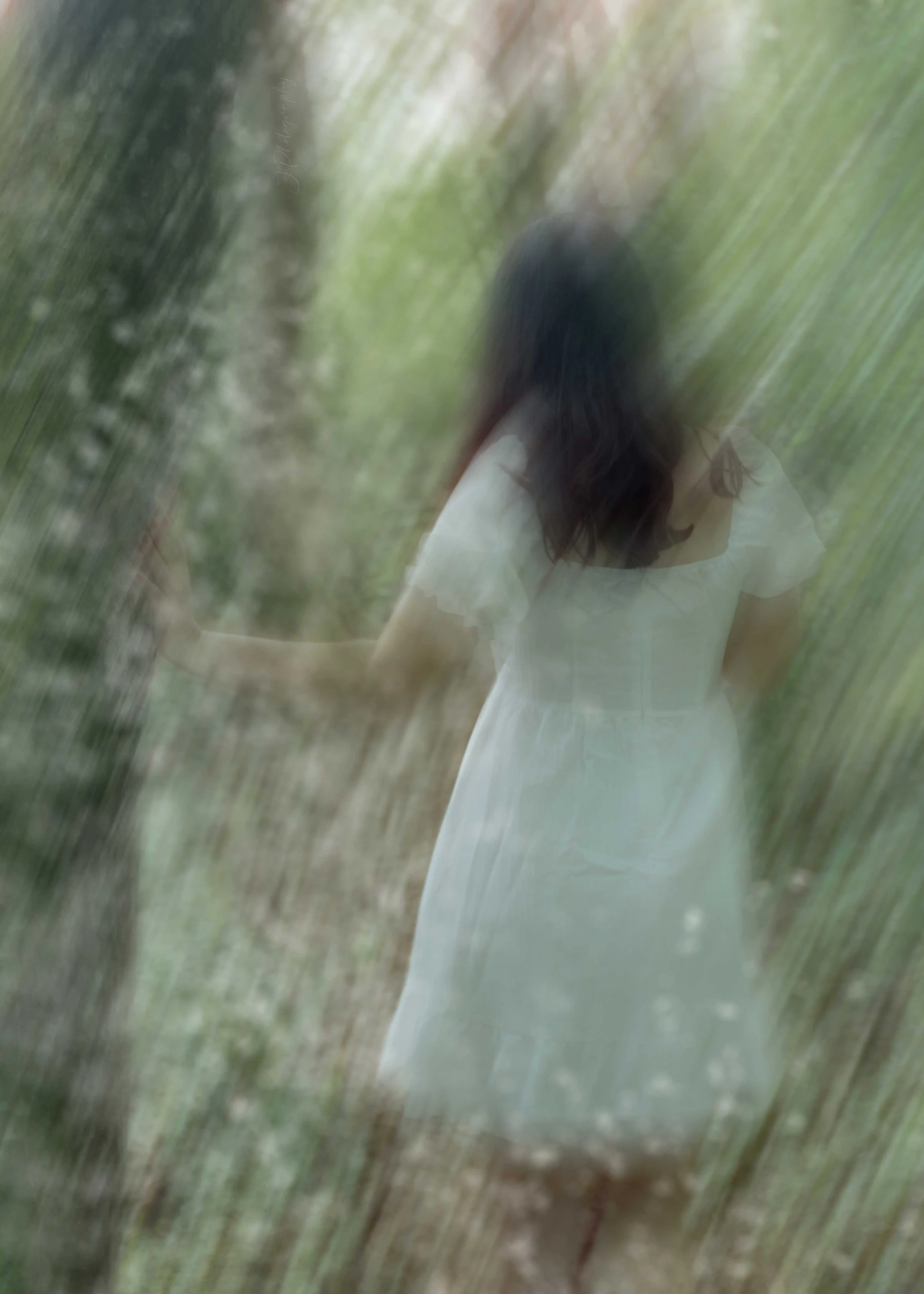 Une femme en robe blanche marchant dans une forêt, vue floue et artistique.