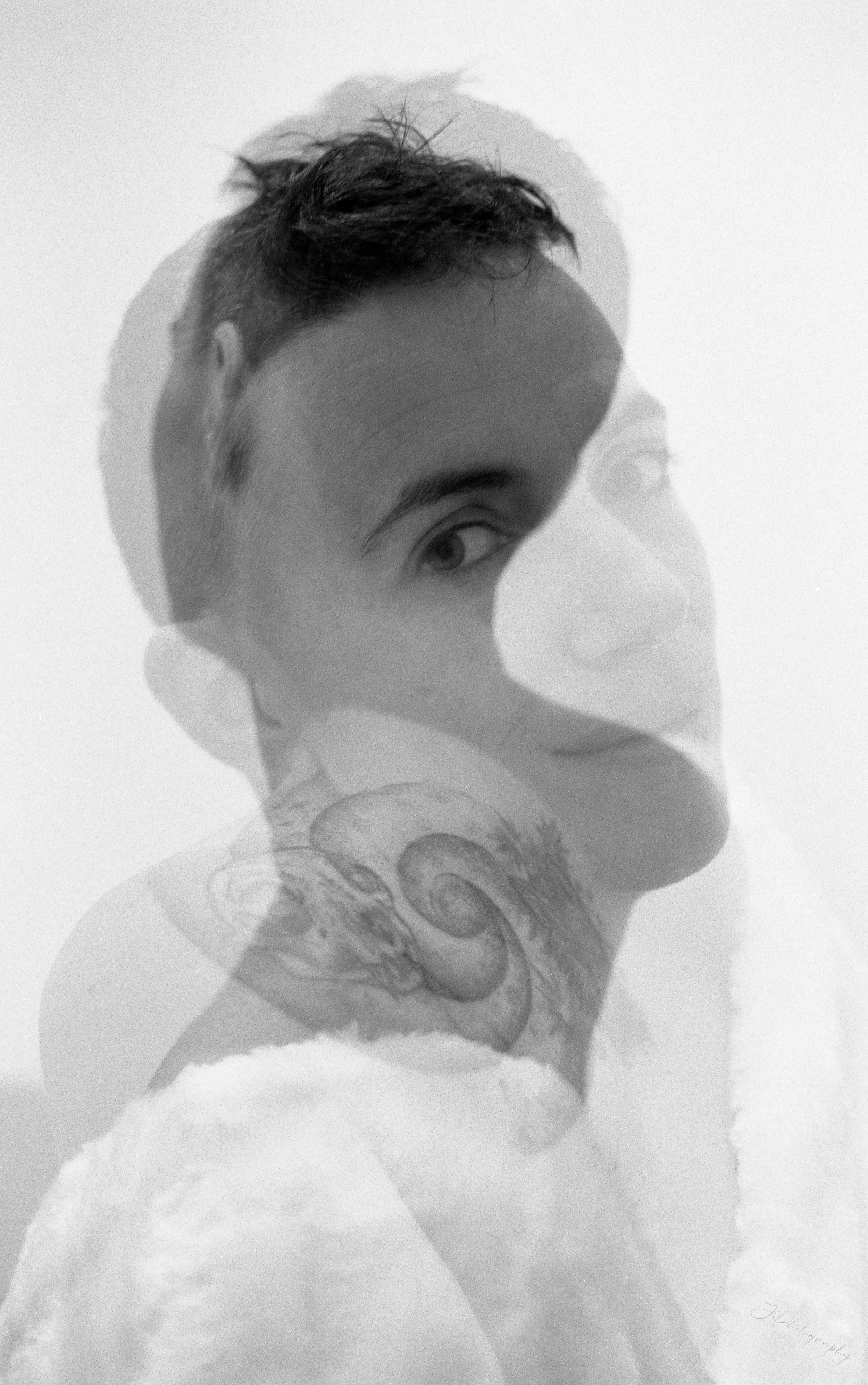 Photo en double exposition d'une femme avec une tête d'homme et une tatouage de spirale sur l'épaule