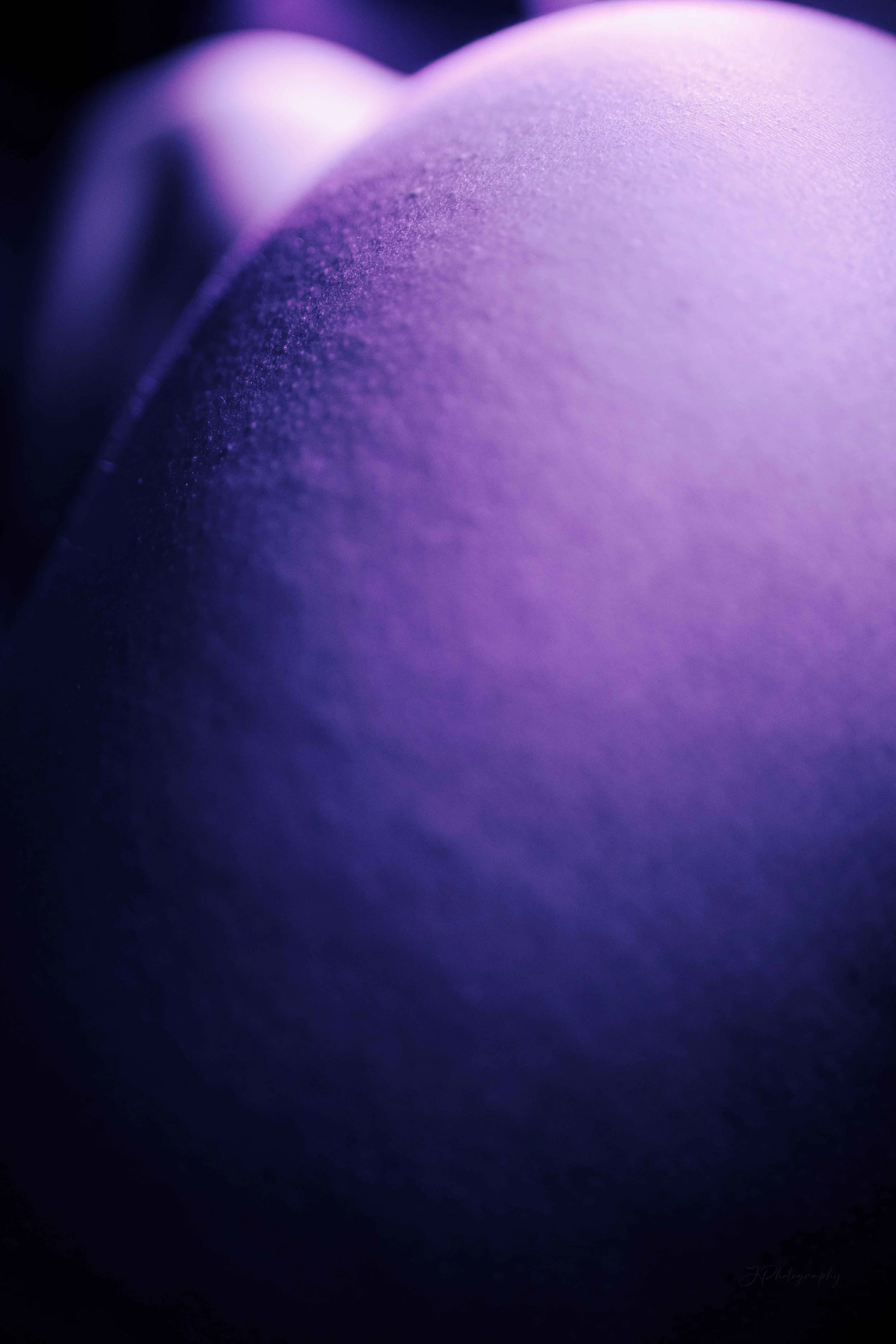 Une vue en gros plan d'une surface violette avec une texture douce et brillante, éclairée par une lumière douce et diffuse.