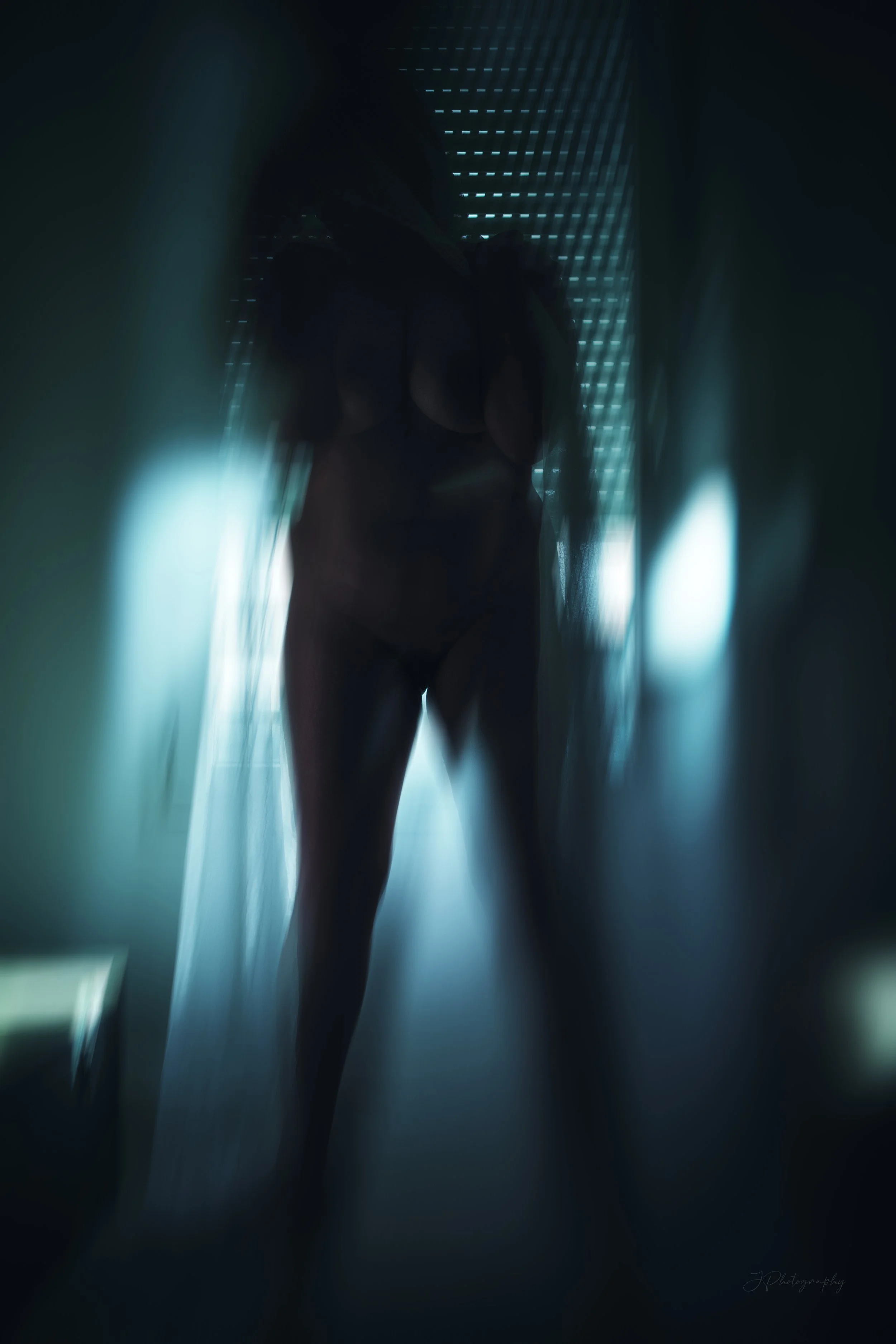 Image impressionniste d'une femme nue postée devant une fenêtre, avec des effets de flou et une teinte bleutée.