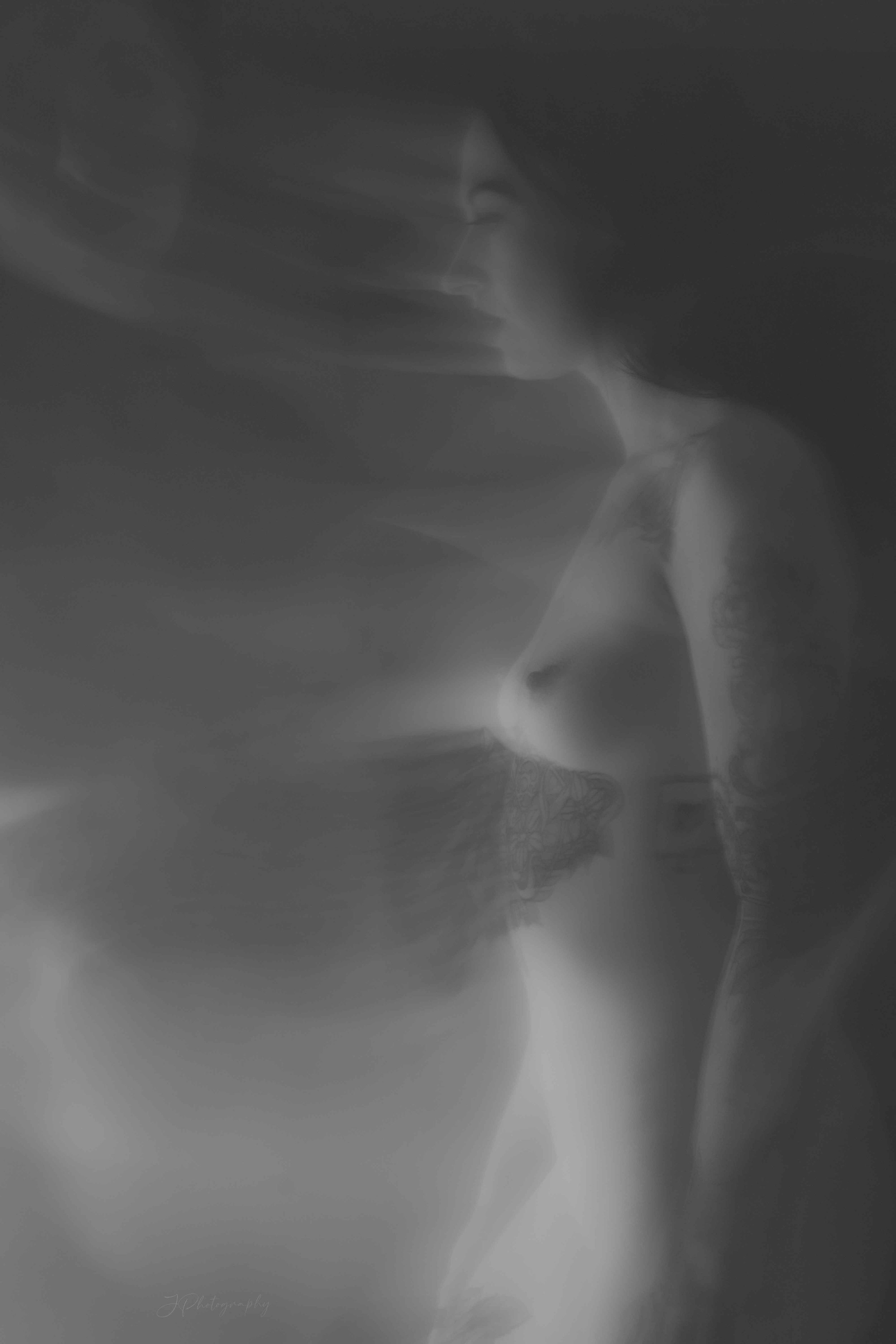 Photo en noir et blanc d'une femme en profil, avec un effet de mouvement flou.