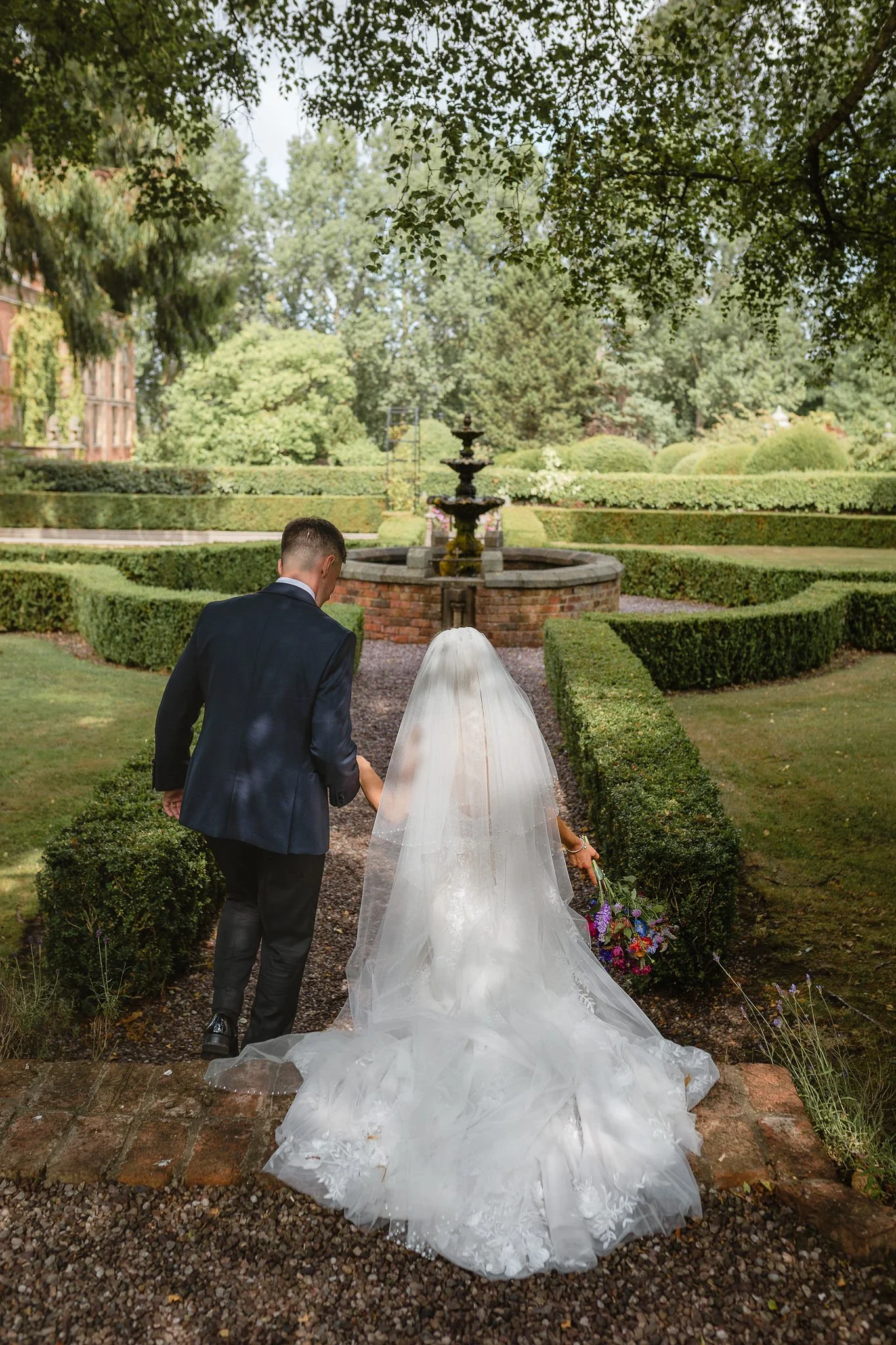 Wedding at the Coach House at Soughton Hall. Couple having portraits in the gardens during their wedding reception.