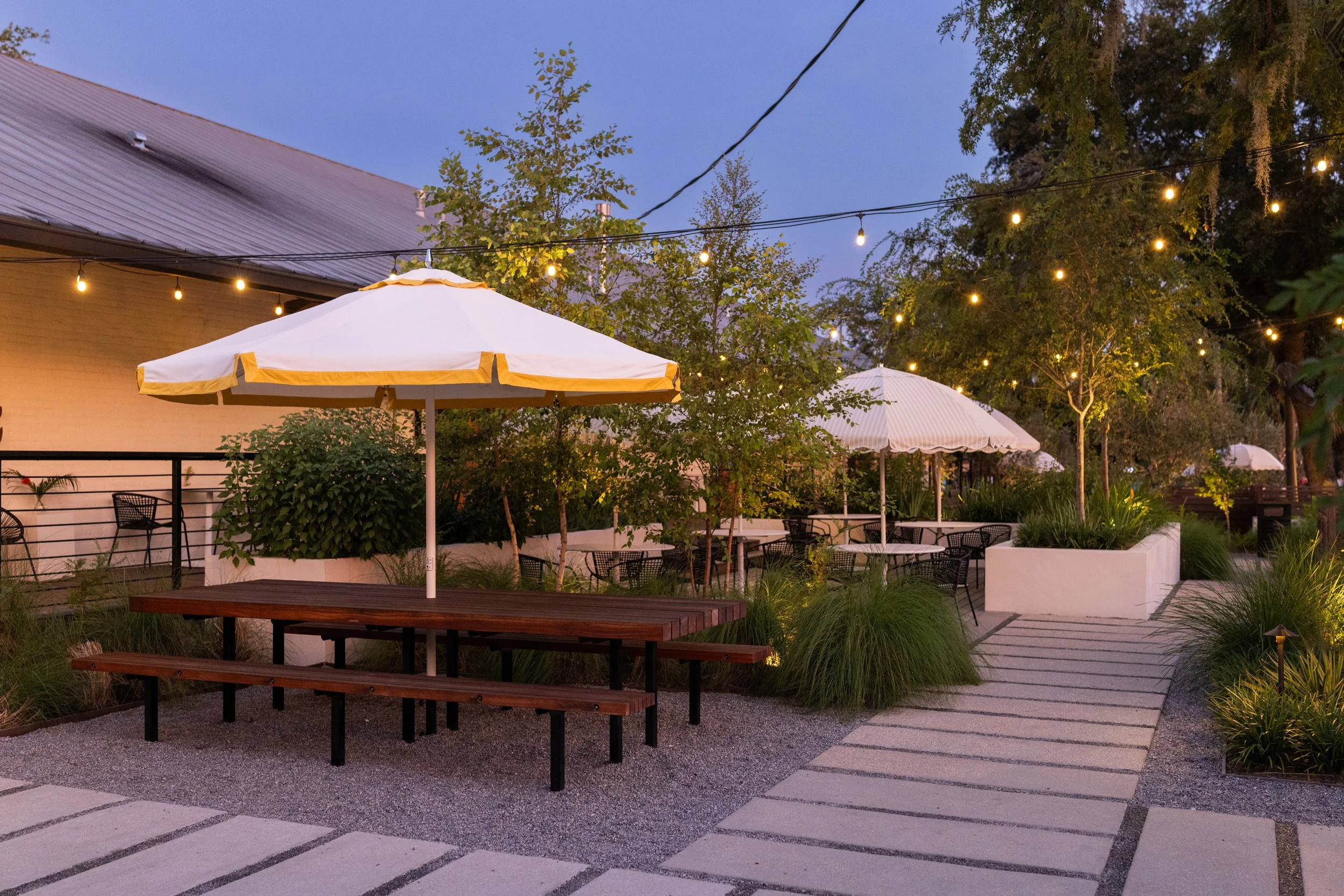 empty garden space with large picnic table and umbrella